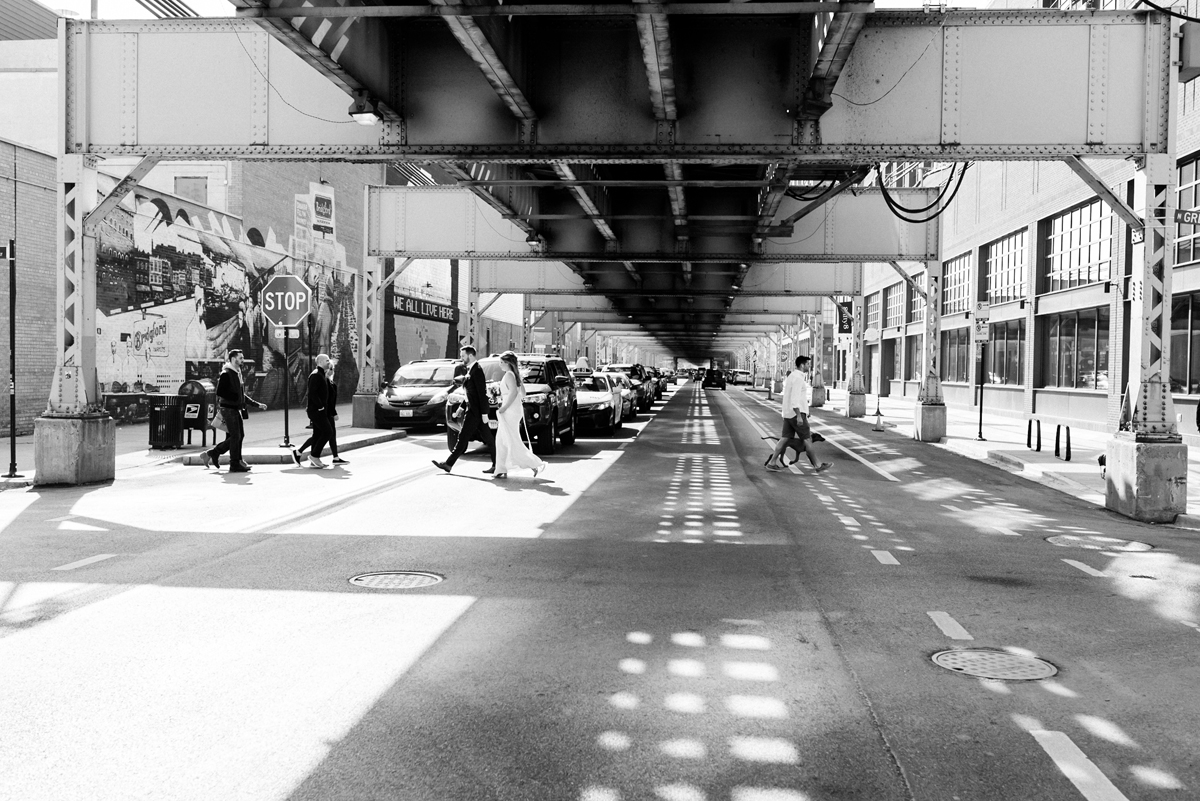Bride and groom walk across Lake St. in Chicago.