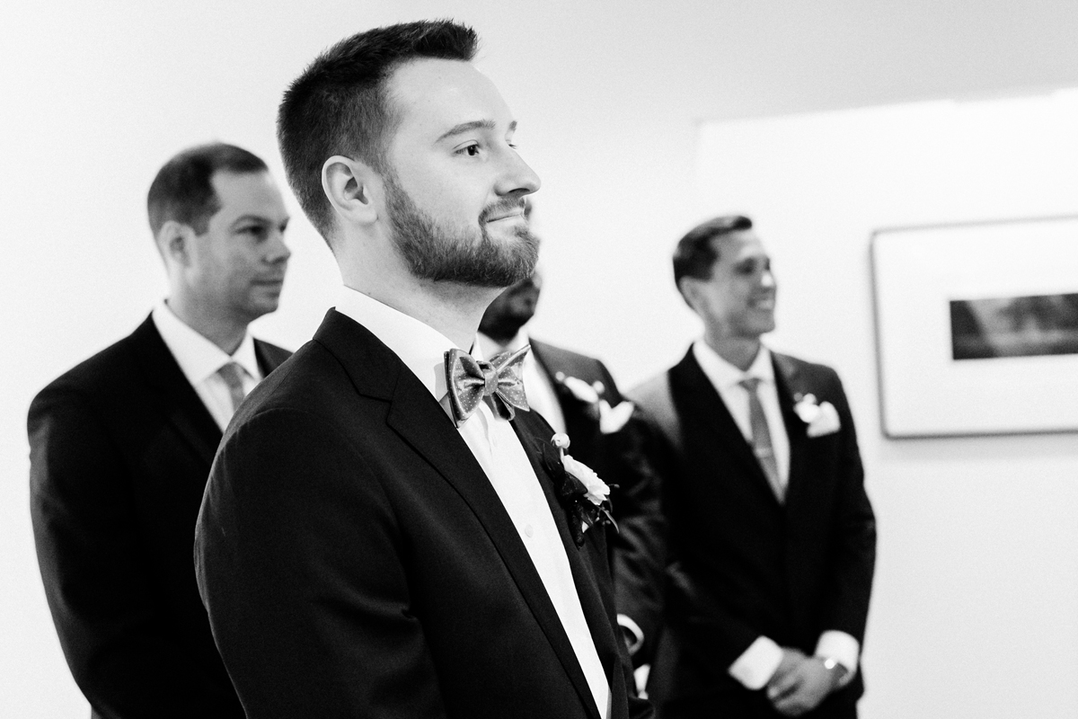 Groom watches his bride walk down the aisle.