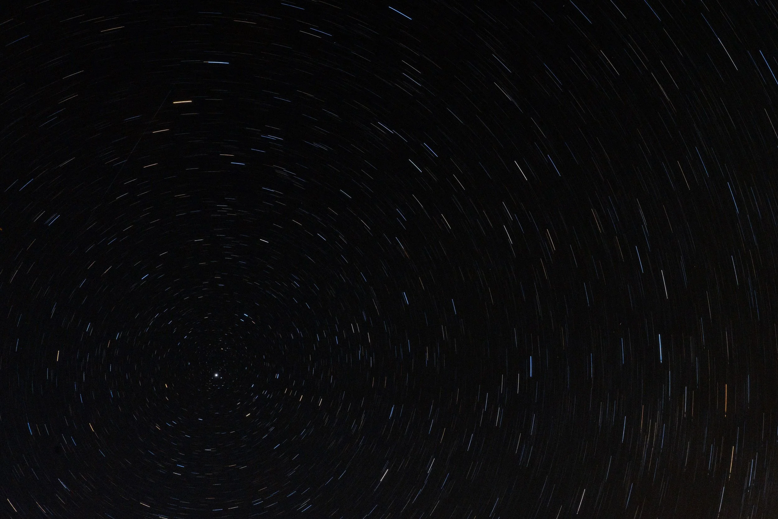Long exposure photograph of star trails in the night sky, showing circular streaks of stars around the celestial pole.