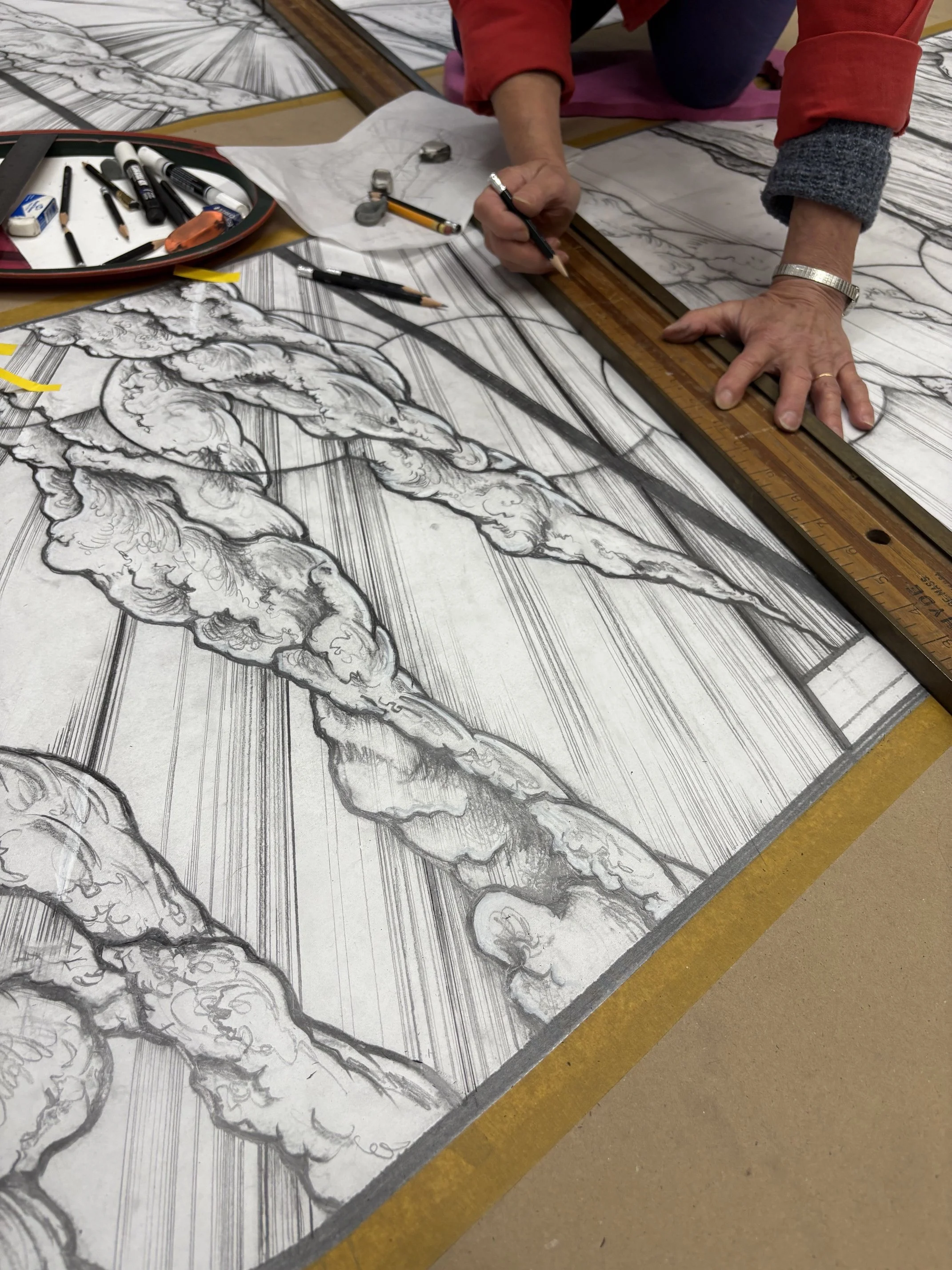 Cartooning for stained glass, Debora Coombs working on full-size drawing of a landscape to be hand-painted and kiln-fired from a mosaic of coloured glass pieces.