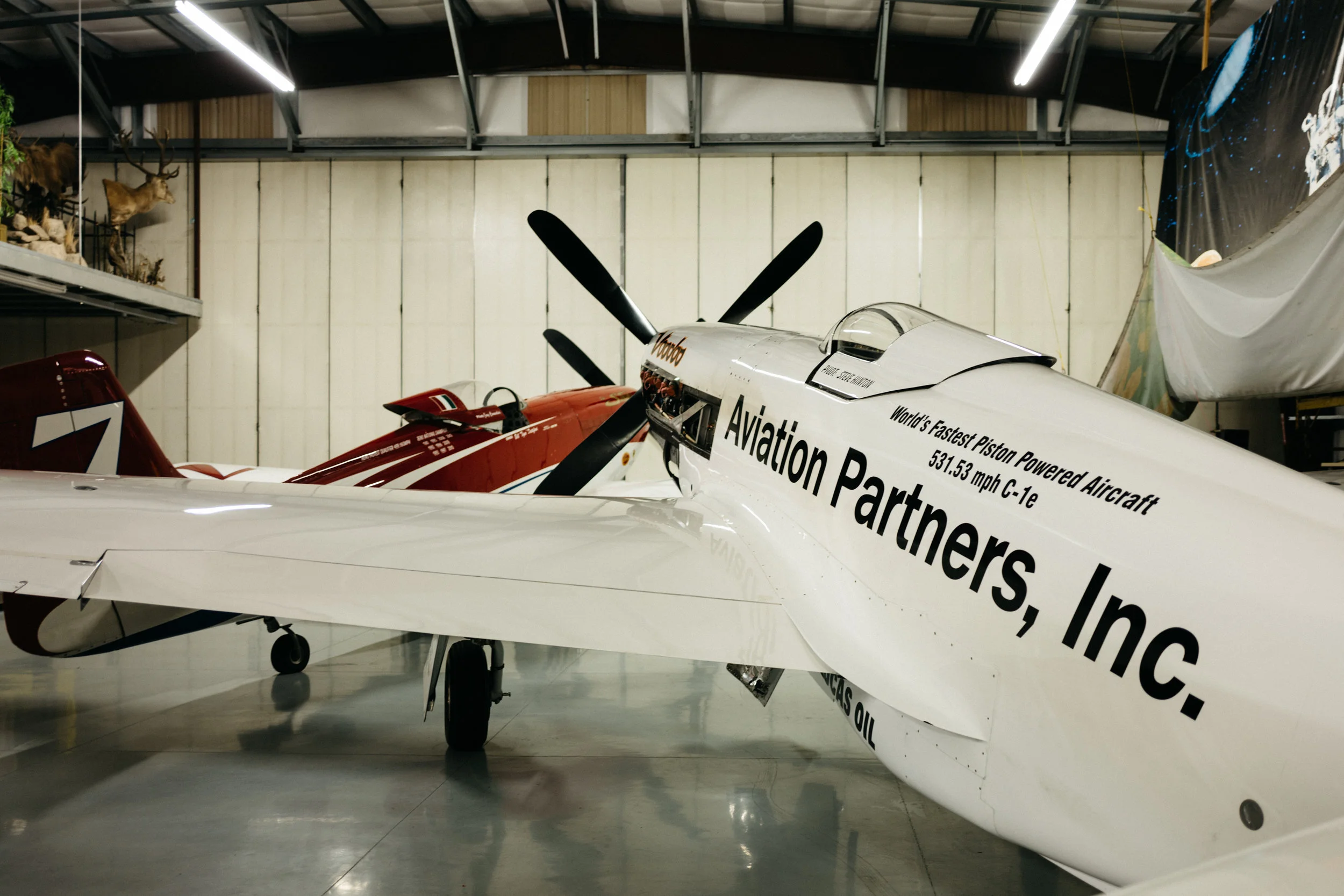 Here, Strega (background) sits with its sibling, Voodoo, another heavily modified P-51, both escaping some bad weather before opening day of the races.