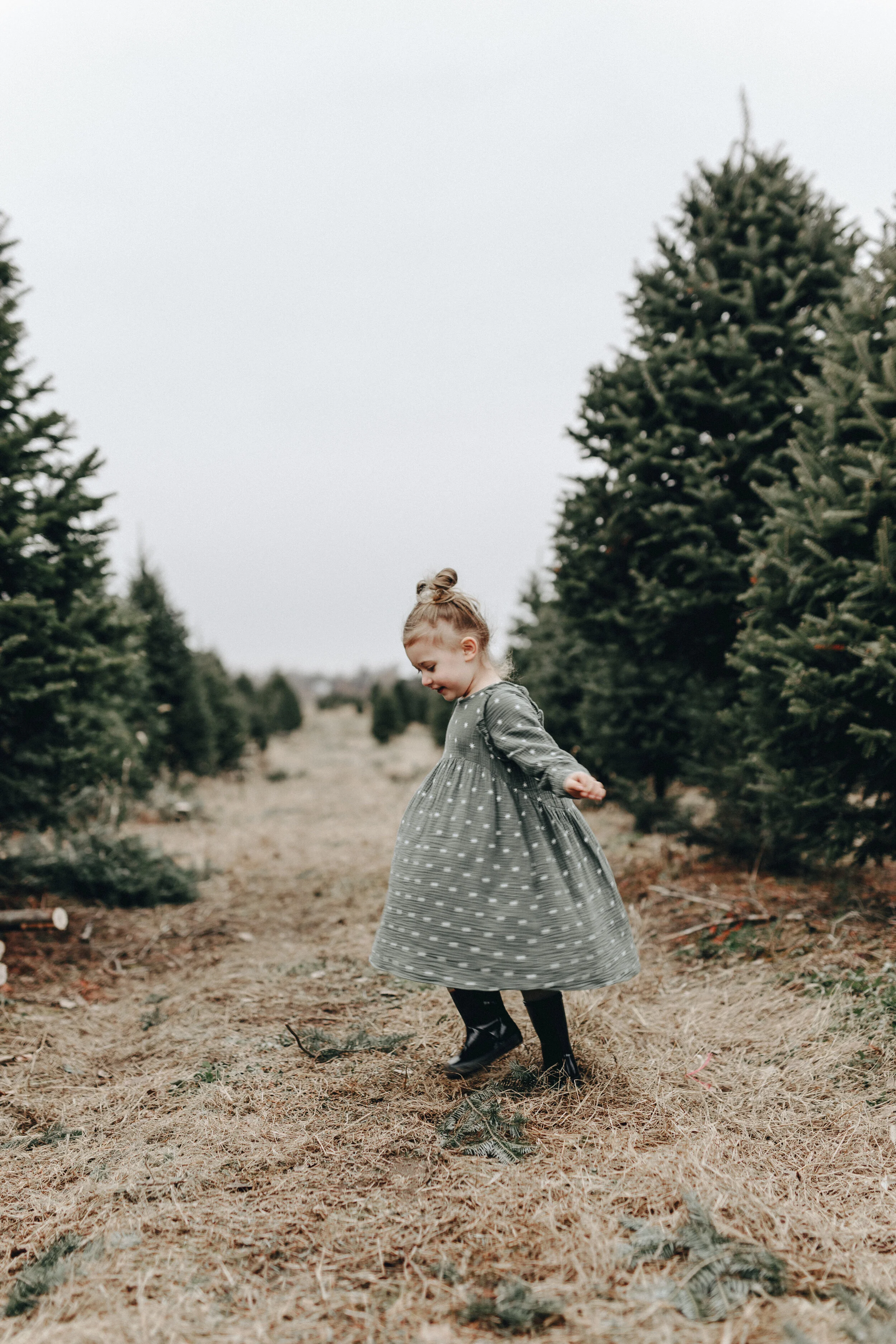 liv price in a dress twirling in the christmas tree farm