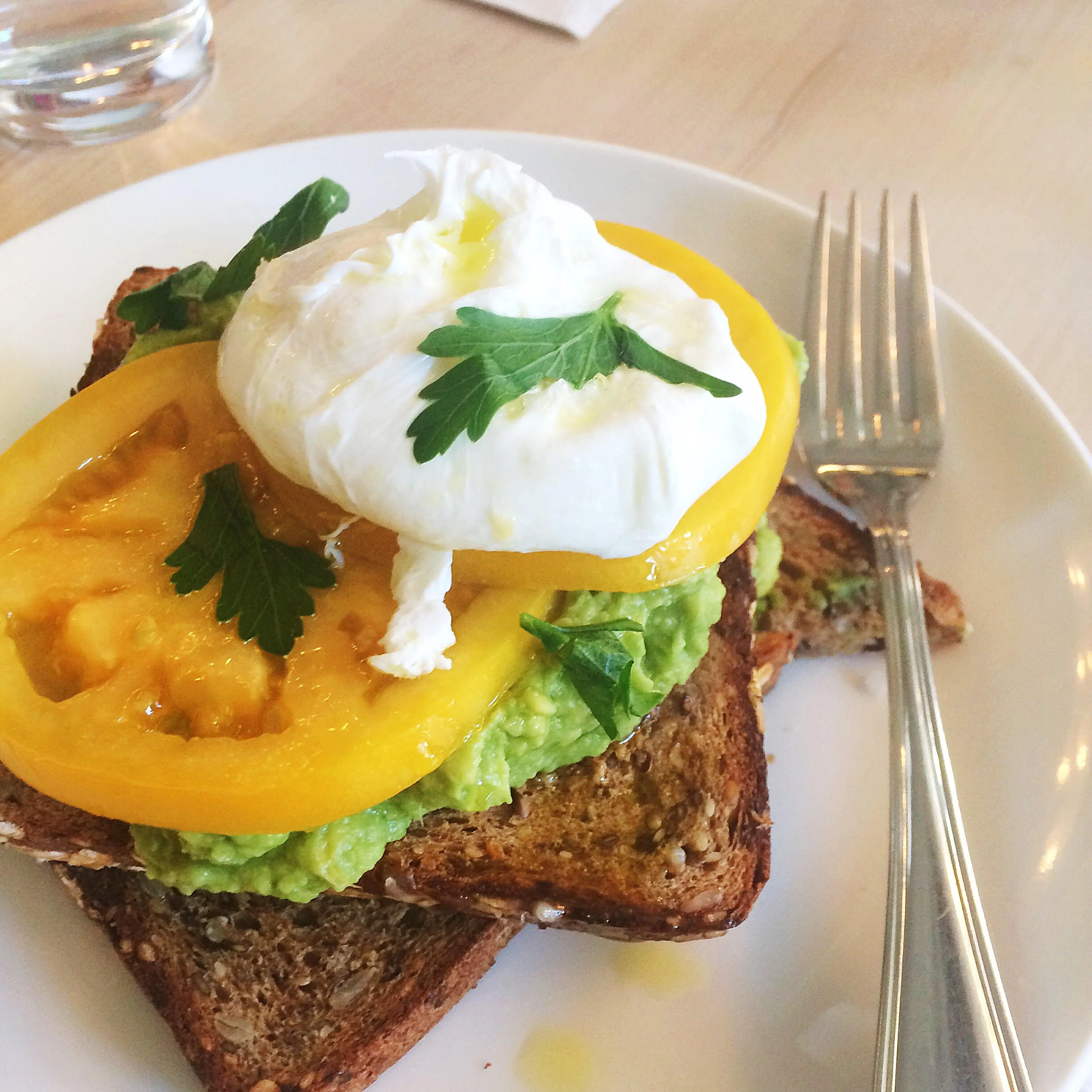 Avocado toast with heirloom tomatoes and a poached egg