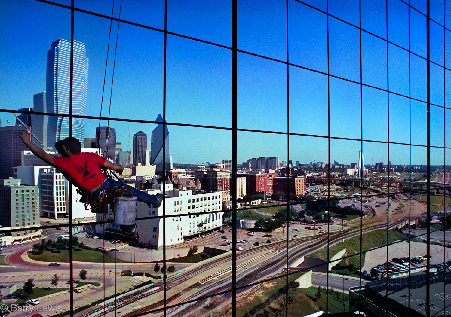  Window cleaner, Dallas, 1996.
Reflected in the windows is Dealey Plaza, the location of the assassination of John F. Kennedy in 1963. 