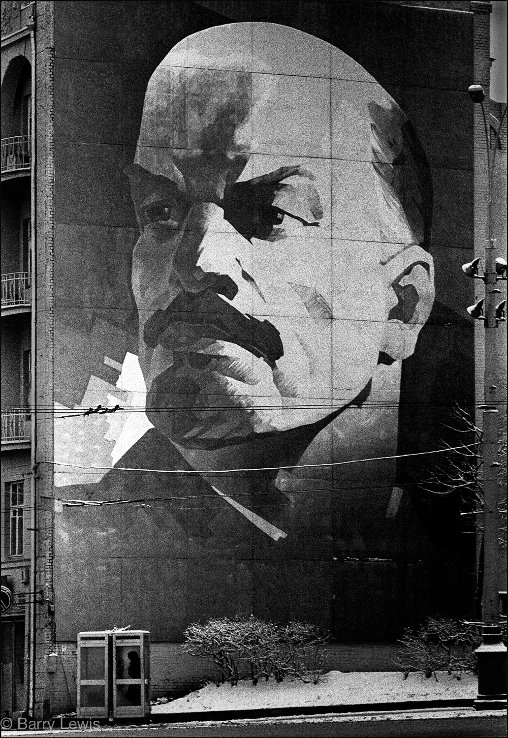 Giant mural of Lenin towering over a telephone box. Moscow, 1972