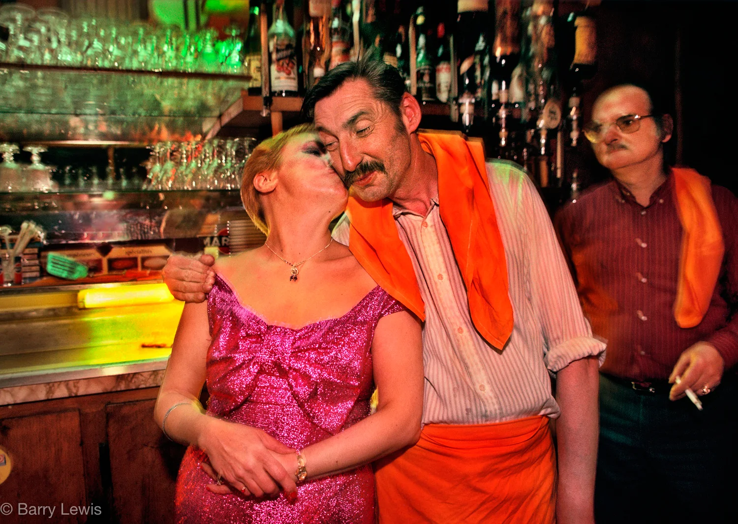A secret kiss for the waiter in Chez Louisette, Paris, 1991. Started in the 1930s, in the heart of the flea market, by Madame Louisette and fuelled by the songs of Edith Piaf, it is a little bit of traditional Paris.