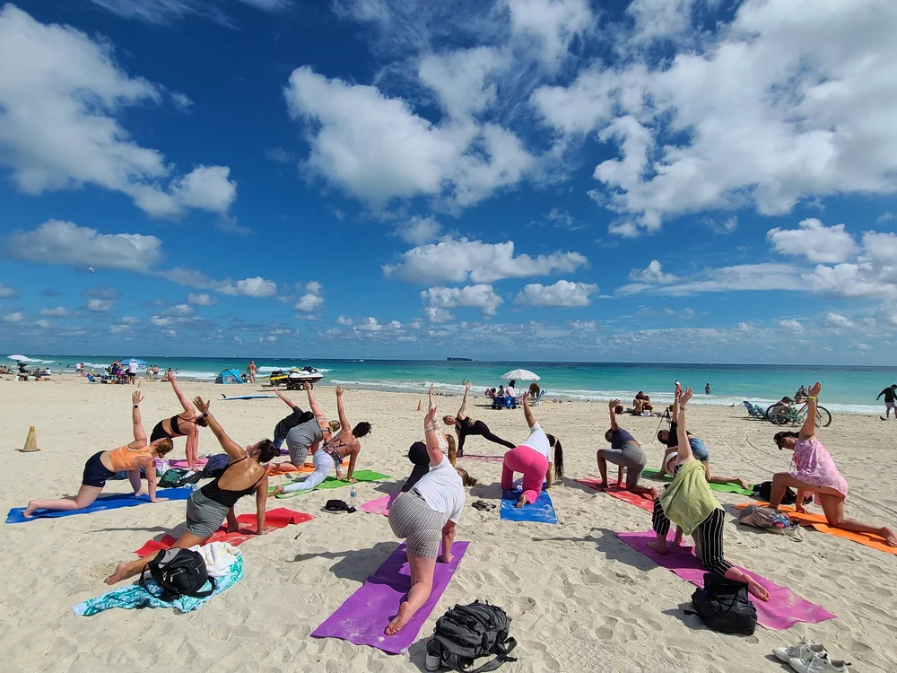 Au pairs doing yoga on the beach