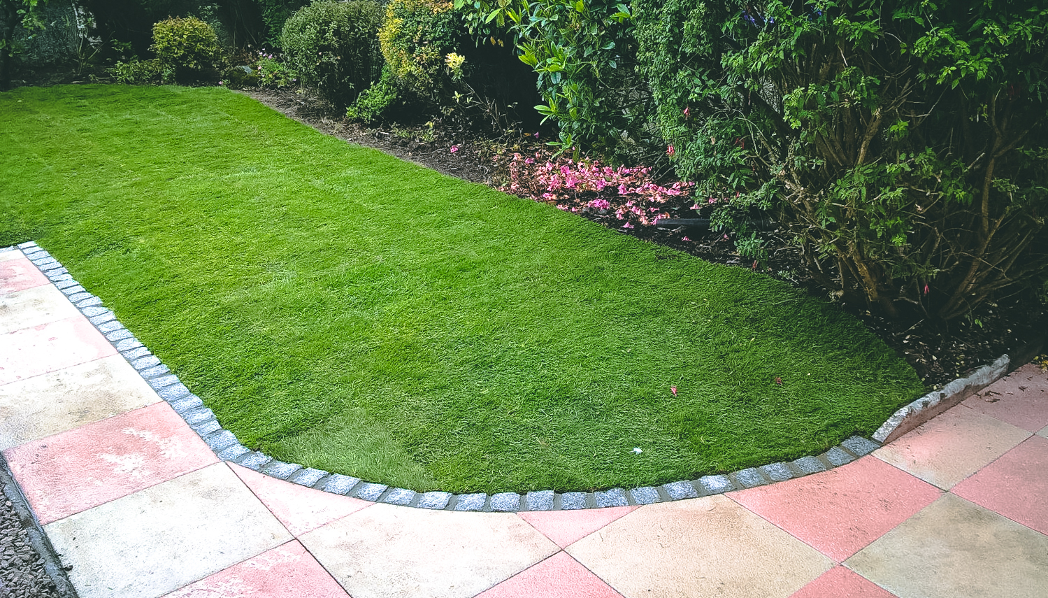 New slabbed area with granite edging and lawn