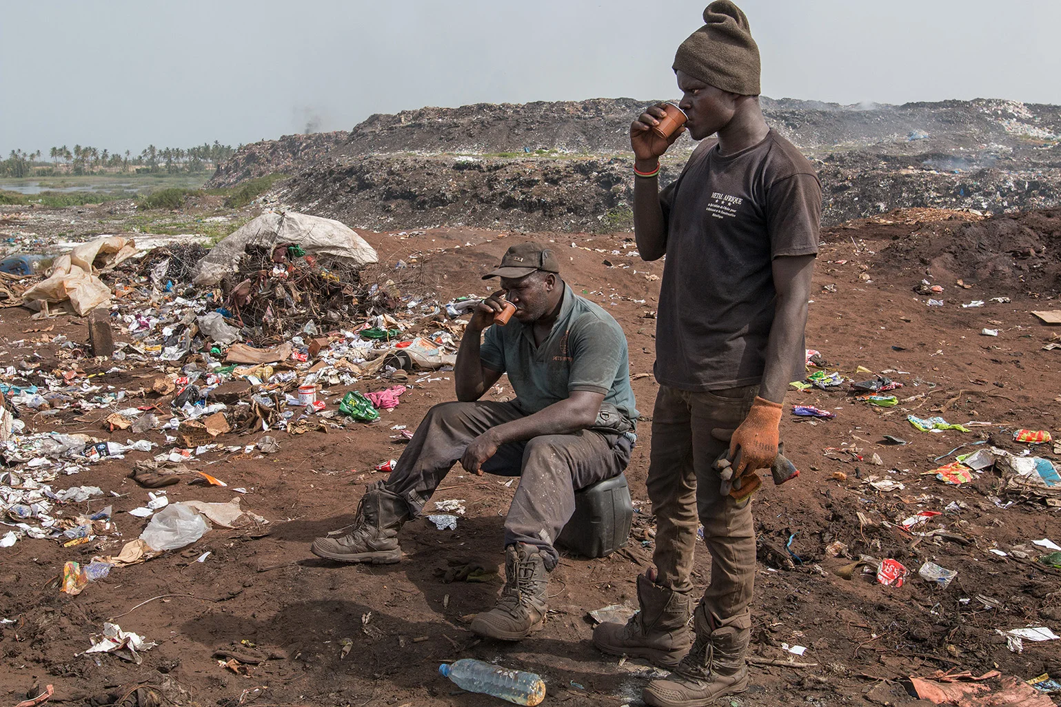 Two waste pickers at the Mbeubeuss landfill. They belong to over 2000 people who search the waste for recyclable material and then sell it. The open landfill is one of the largest in the world, with around 2000 tons being unloaded every day. Zwei Abfallsucher der Deponie Mbeubeuss. Sie gehören zu über 2000 Personen, die den Abfall nach wiederverwertbarem Material durchsuchen, um es danach zu verkaufen. Die offene Mülldeponie gehört zu den grössten der Welt, rund 2000 Tonnen werden täglich dort abgeladen.