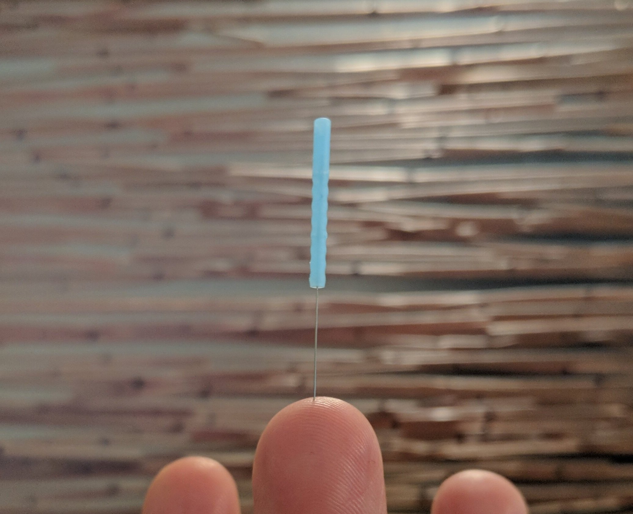 An acupuncture needle on a finger