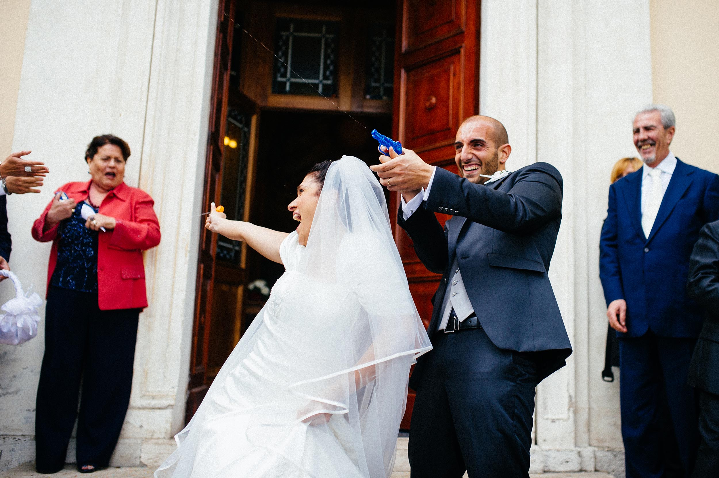 bride-and-groom-outside-the-church-shoot-guests-with-water-guns.jpg