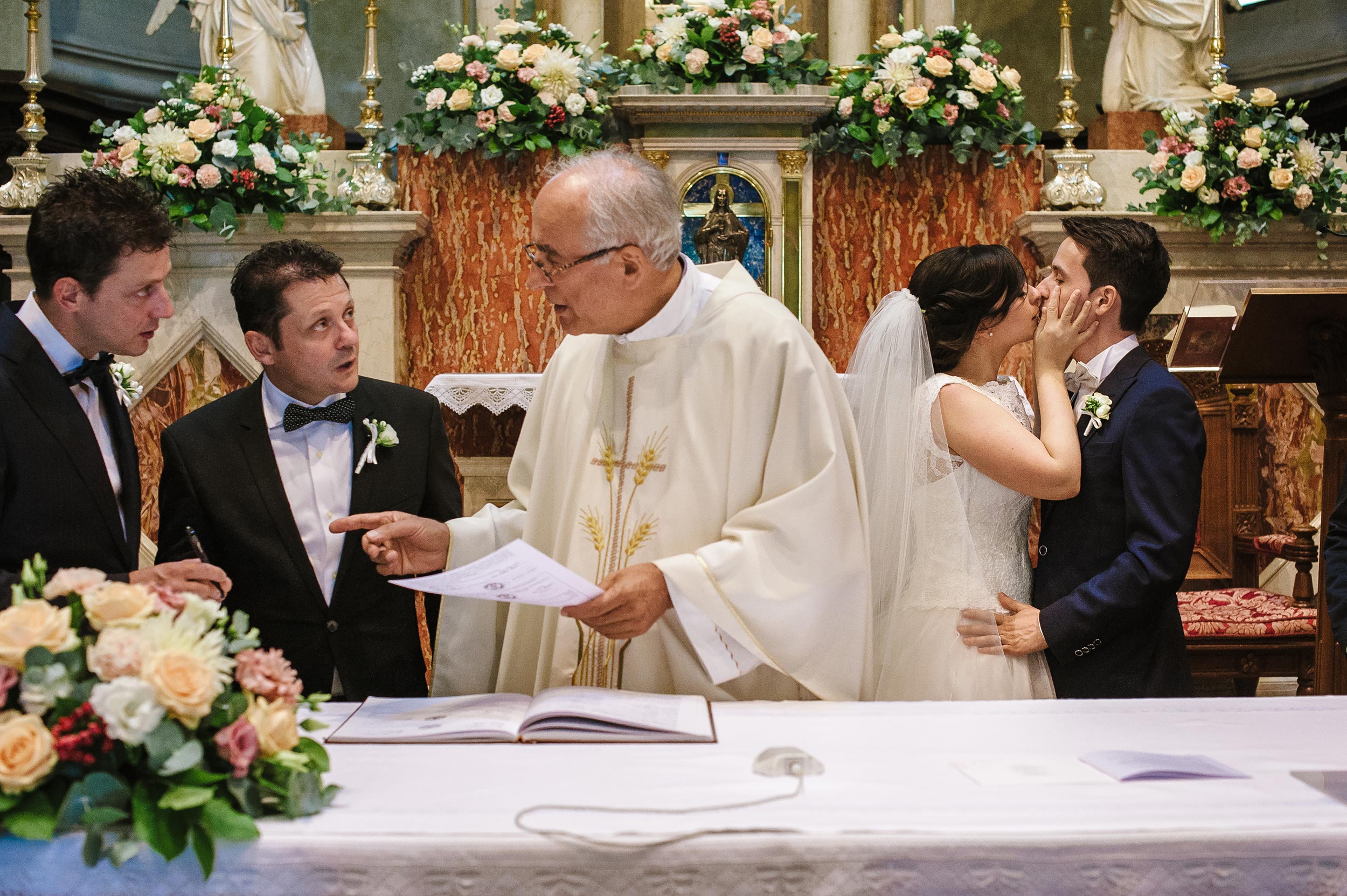 the-bride-kisses-the-groom-in-church-while-witnesses-wait-to-sign.jpg
