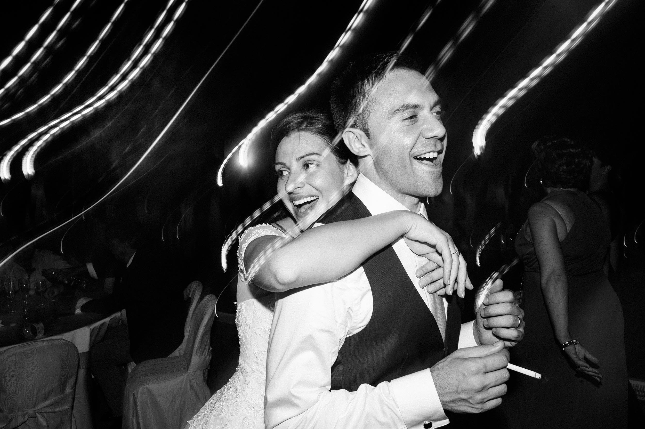 bride-hugs-the-groom-during-wedding-reception-black-and-white-wedding-photography.jpg