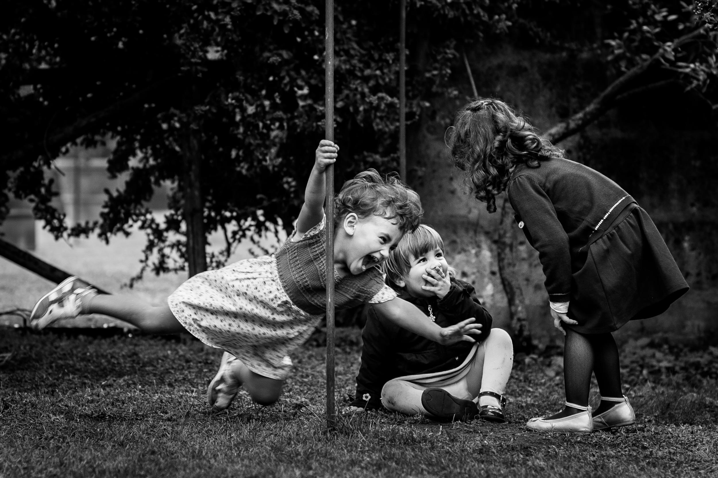 girl-playing-with-a-pole-among-children-black-and-white-wedding-photography.jpg