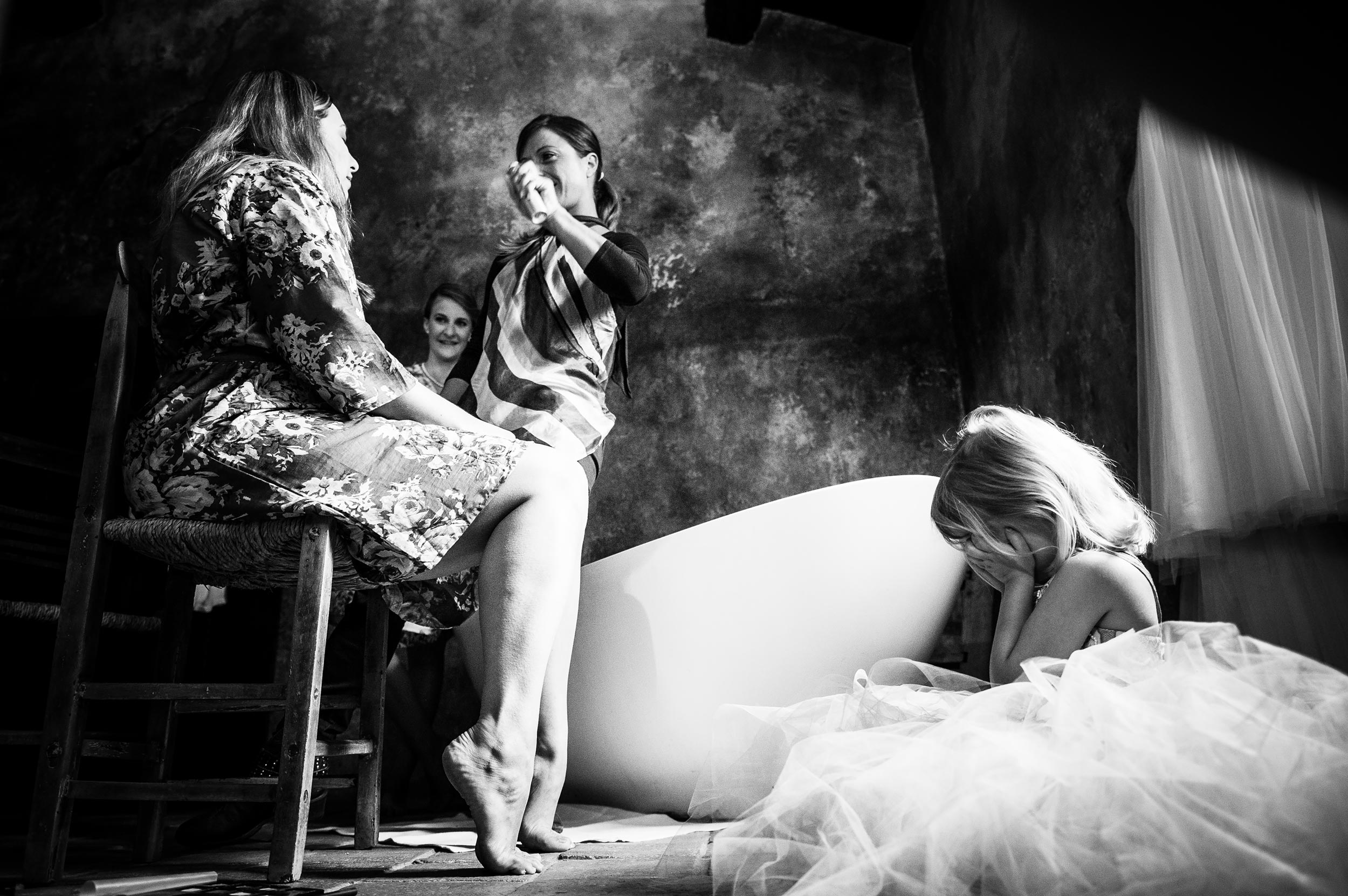 girl-puts-her-hands-on-her-face-while-mom-get-sprayed-during-getting-ready-black-and-white-wedding-photography.jpg