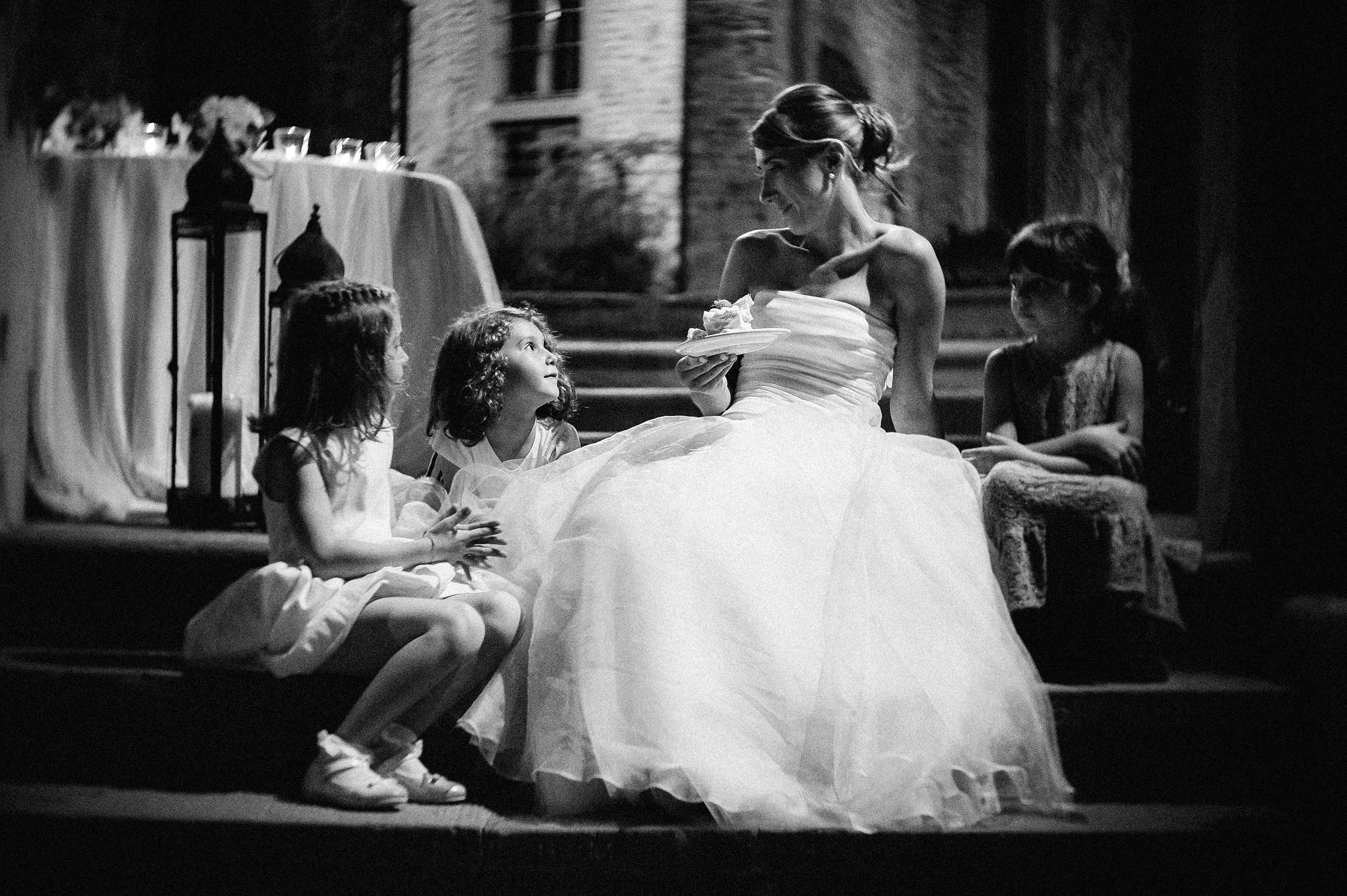 girls-around-the-bride-relaxed-moment-eating-cake-black-and-white-wedding-photography.jpg