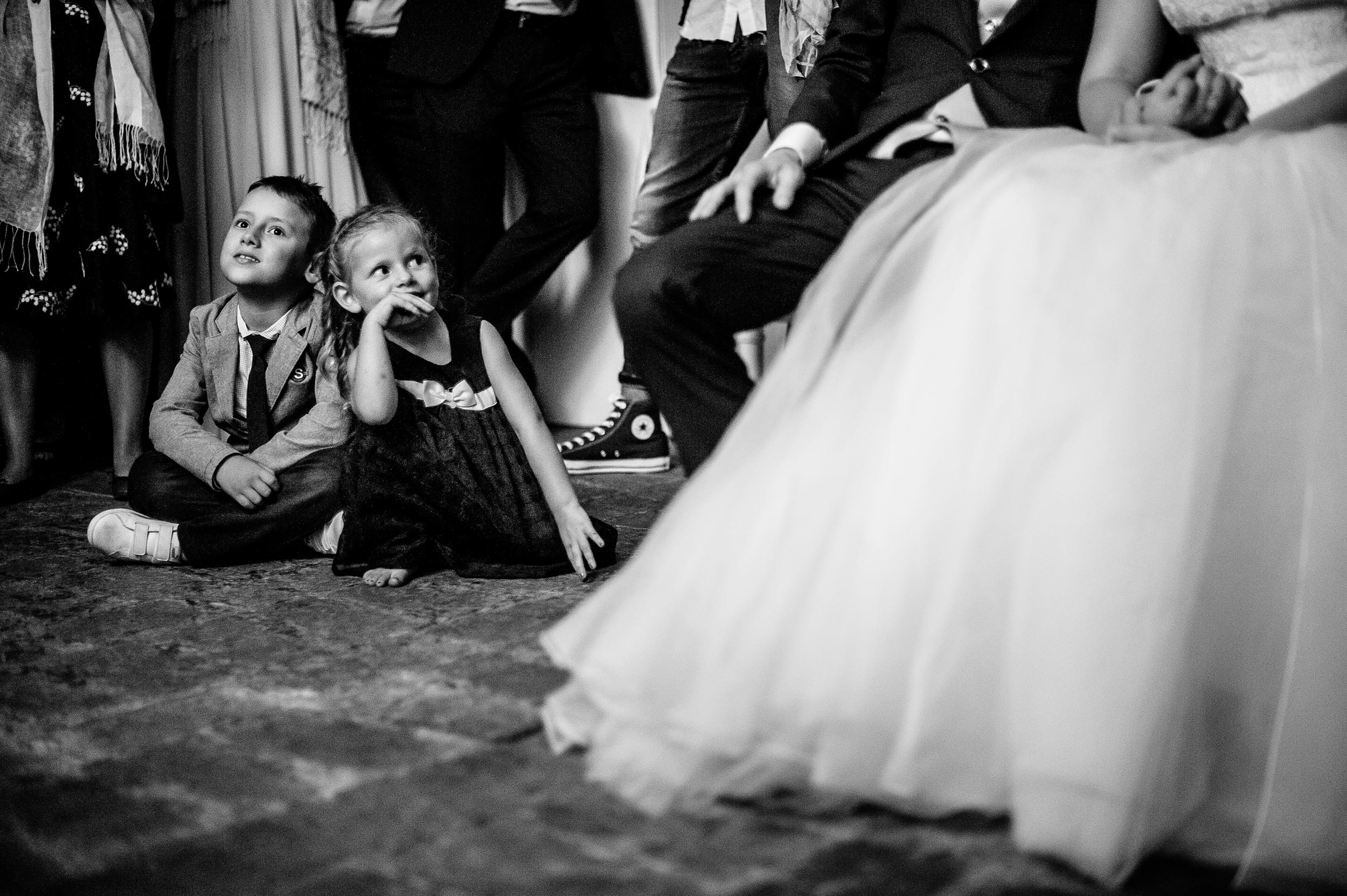 girl-stares-at-the-bride-dreaming-during-short-movi-projection-black-and-white-wedding-photography.jpg