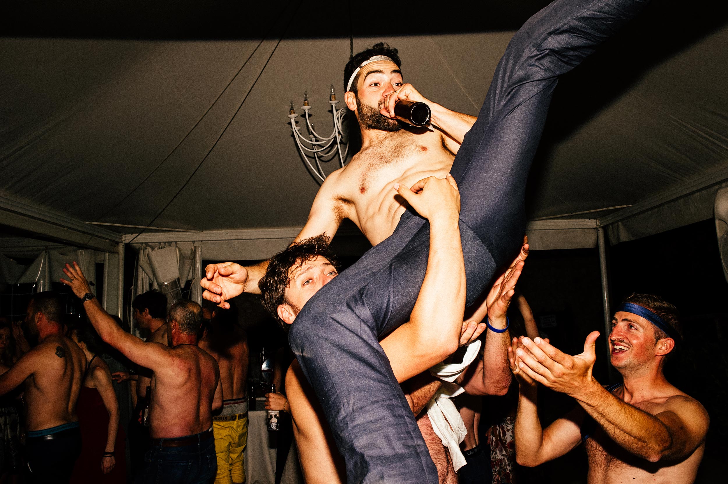 groom-being-thrown-in-the-air-naked-while-drinking-beer-during-wedding-reception-dancing.jpg