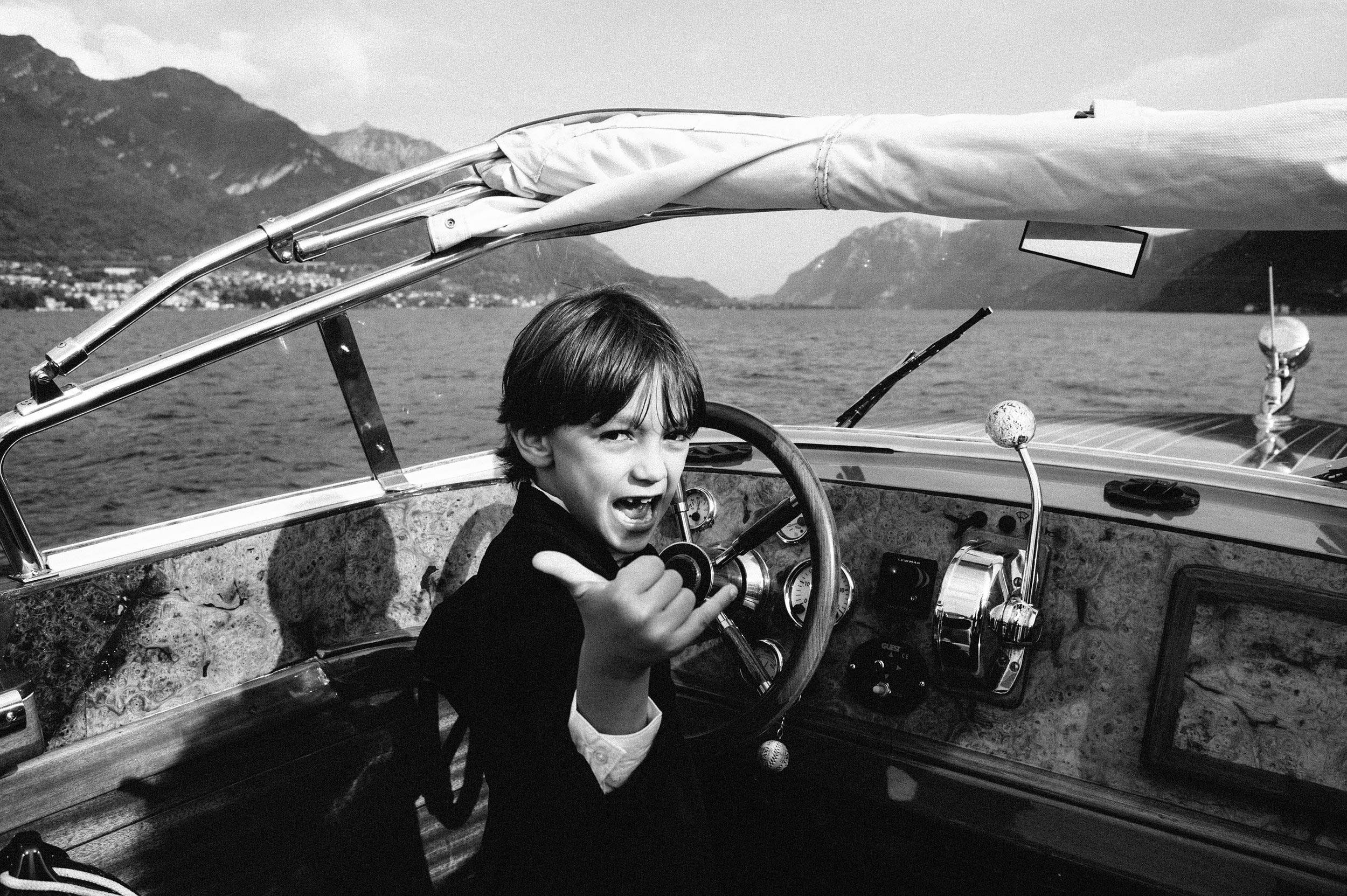 kid-driving-a-motorboat-on-lake-como-black-and-white-wedding-photography.jpg
