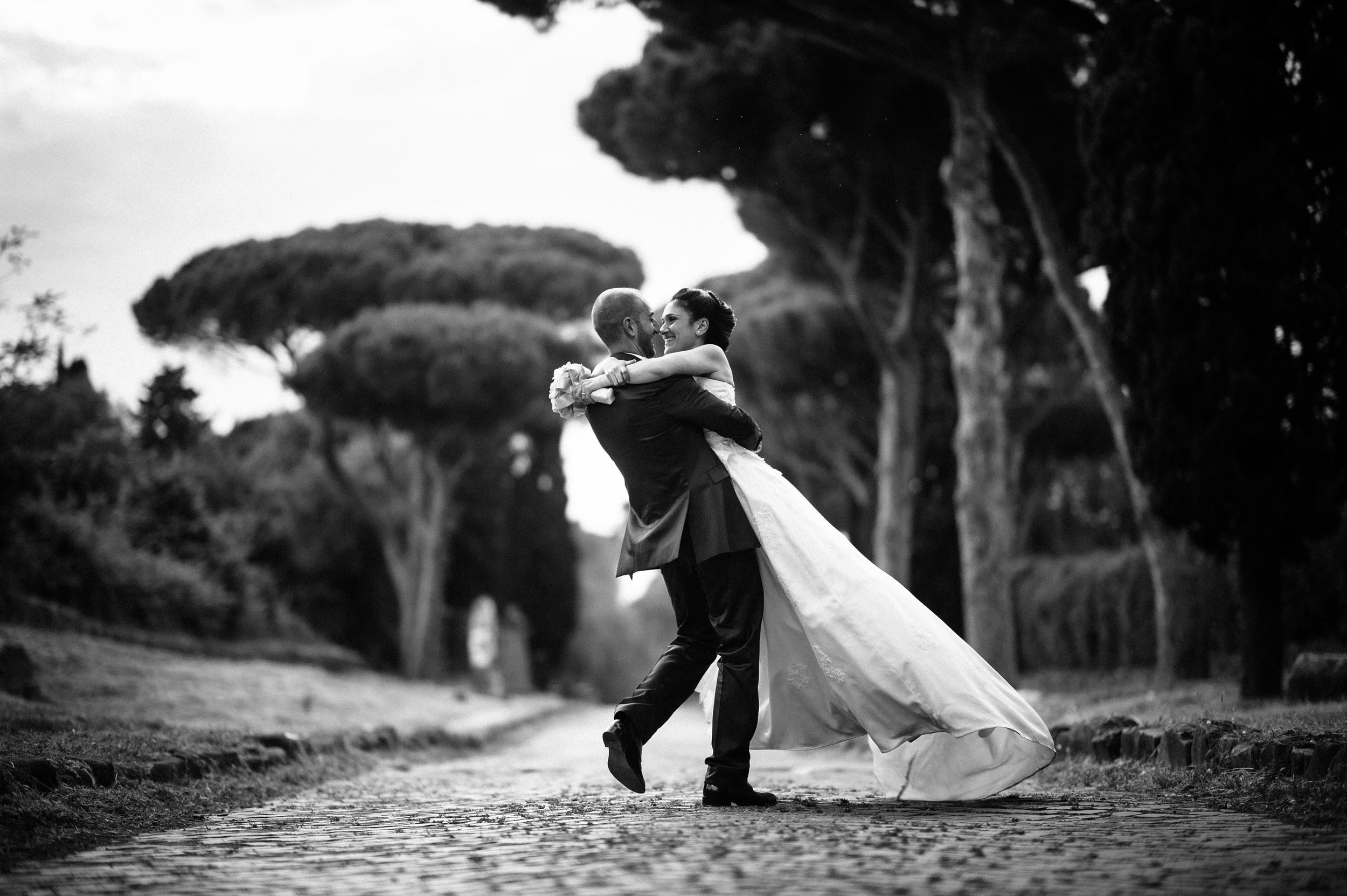 via-appia-antica-bride-and-groom-holding-and-dancing-black-and-white-wedding-photography.jpg