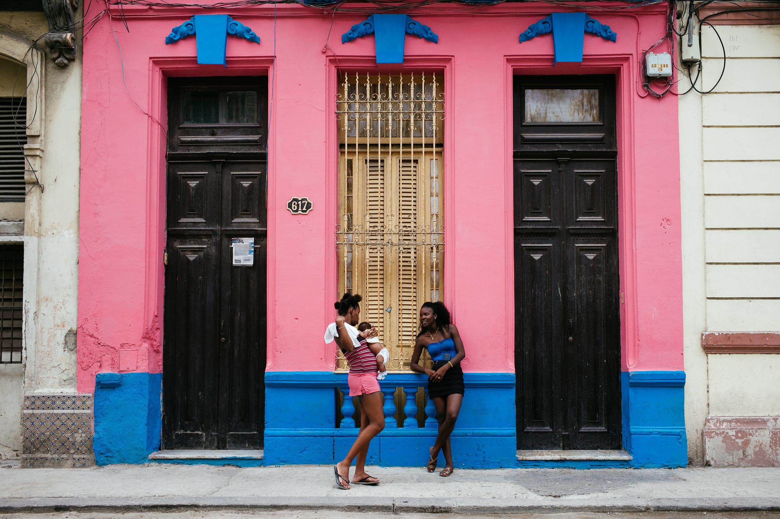 La-Habana-2016-two-ladies-standing-building-has-colors-of-their-clothes-street-photography-by-Alessandro-Avenali.jpg