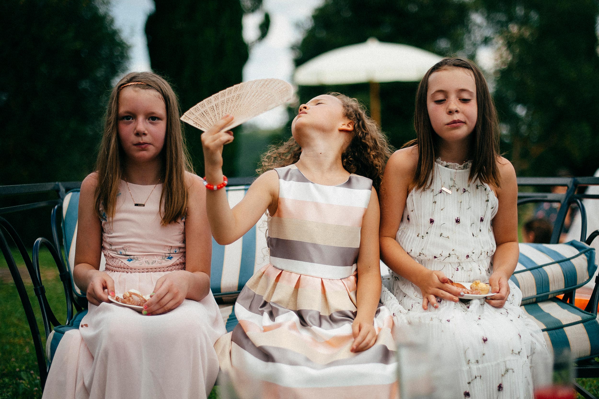 girls-at-the-reception-using-fan-hot-weather-documentary-wedding-photography-in-tuscany-by-Alessandro-Avenali.jpg