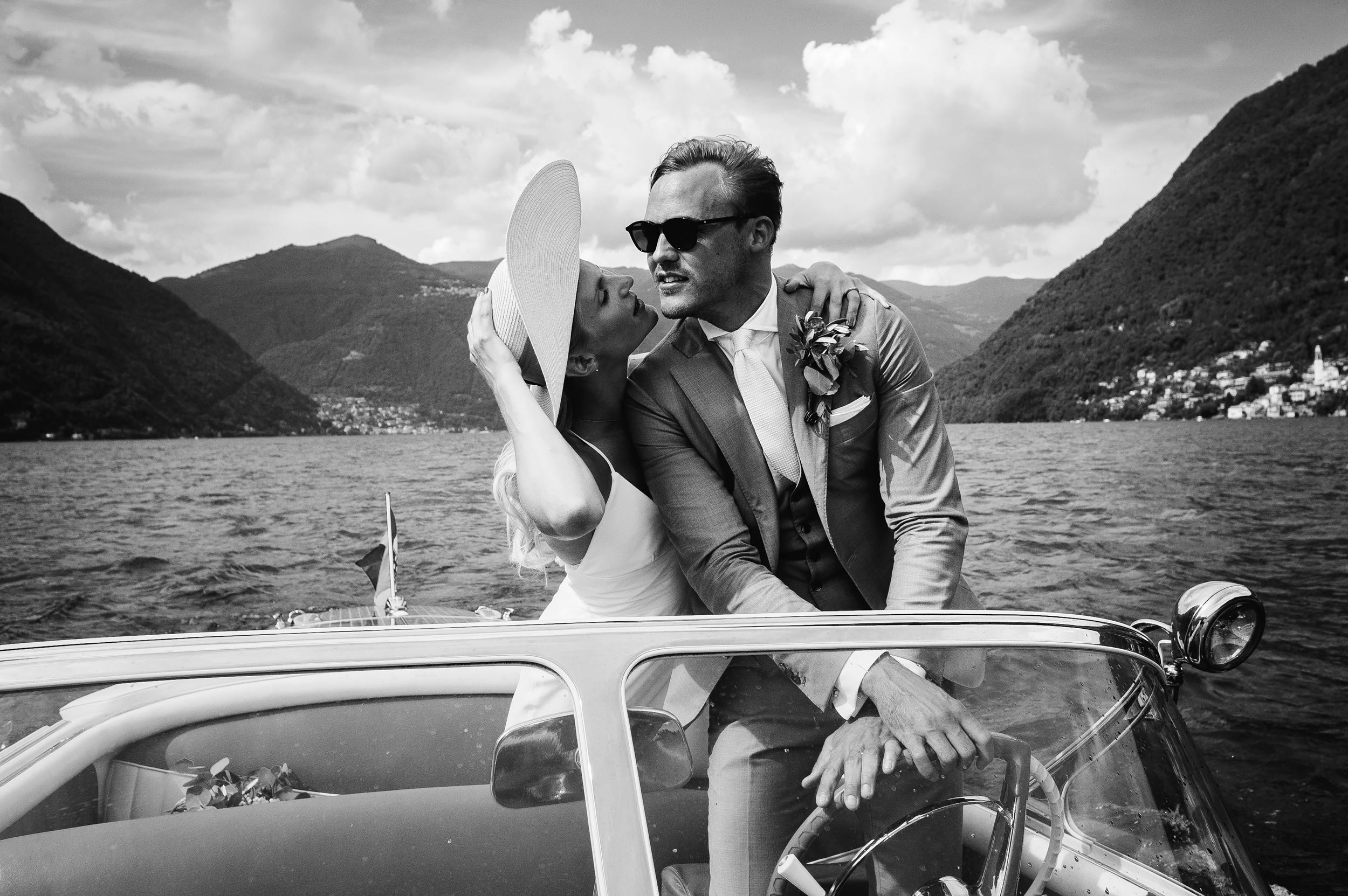 lake-como-wedding-photographer-Alessandro-Avenali-bride-and-groom-driving-riva-yacht-motorboat-black-and-white.jpg