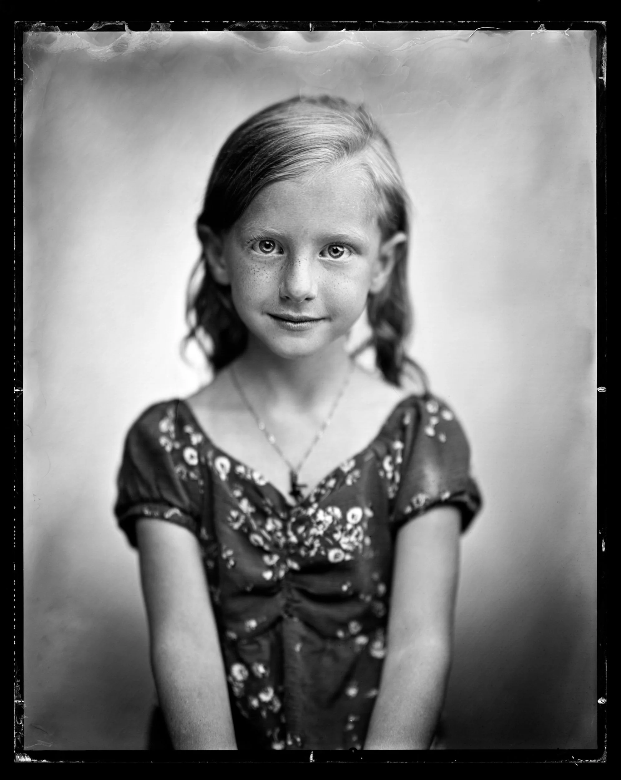30-families-young-girl-in-a-floral-dress-and-pendant-necklace-smiling-a80.jpg