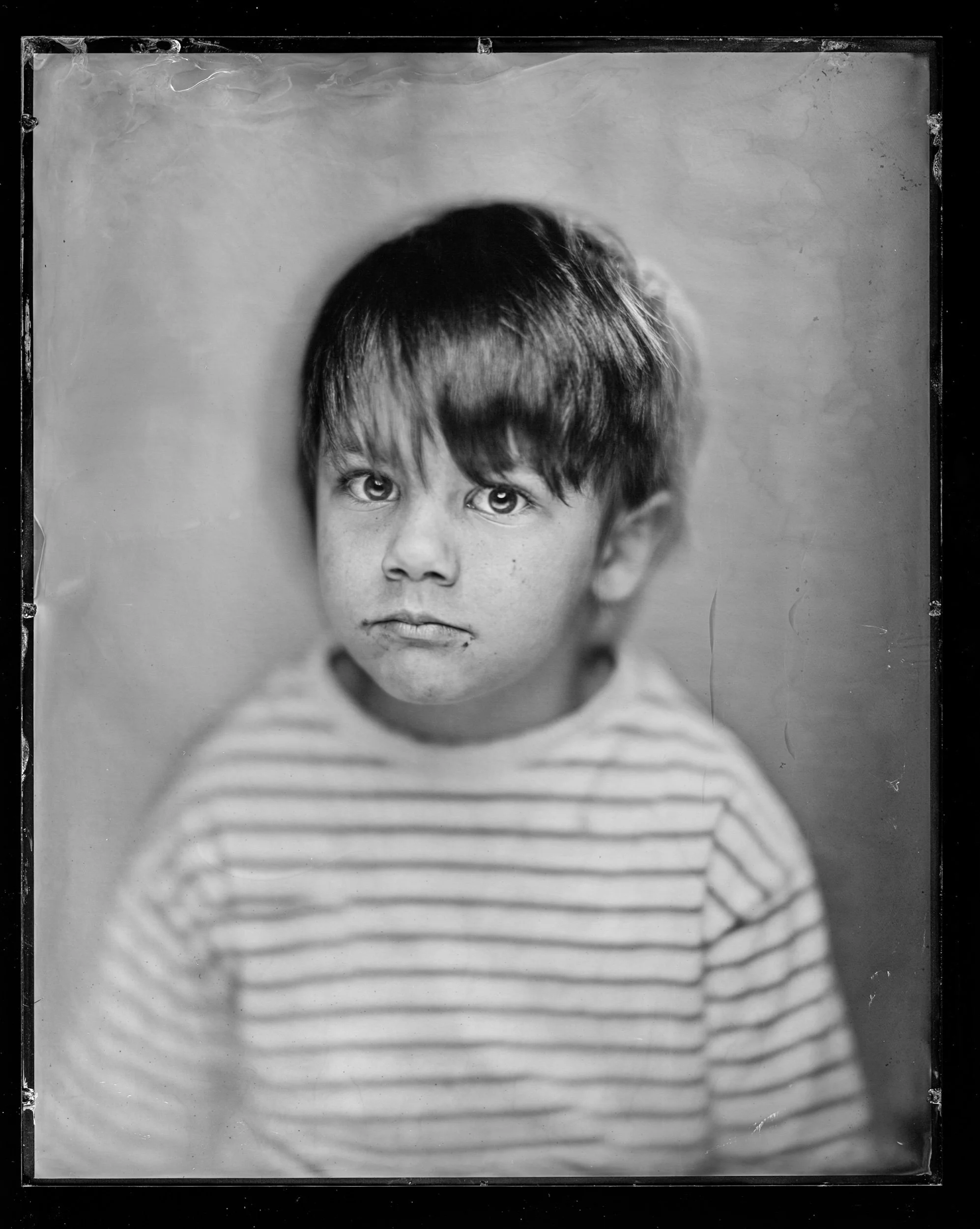 35-families-small-boy-in-a-striped-jumper-with-a-solemn-downturned-mouth-a87.jpg