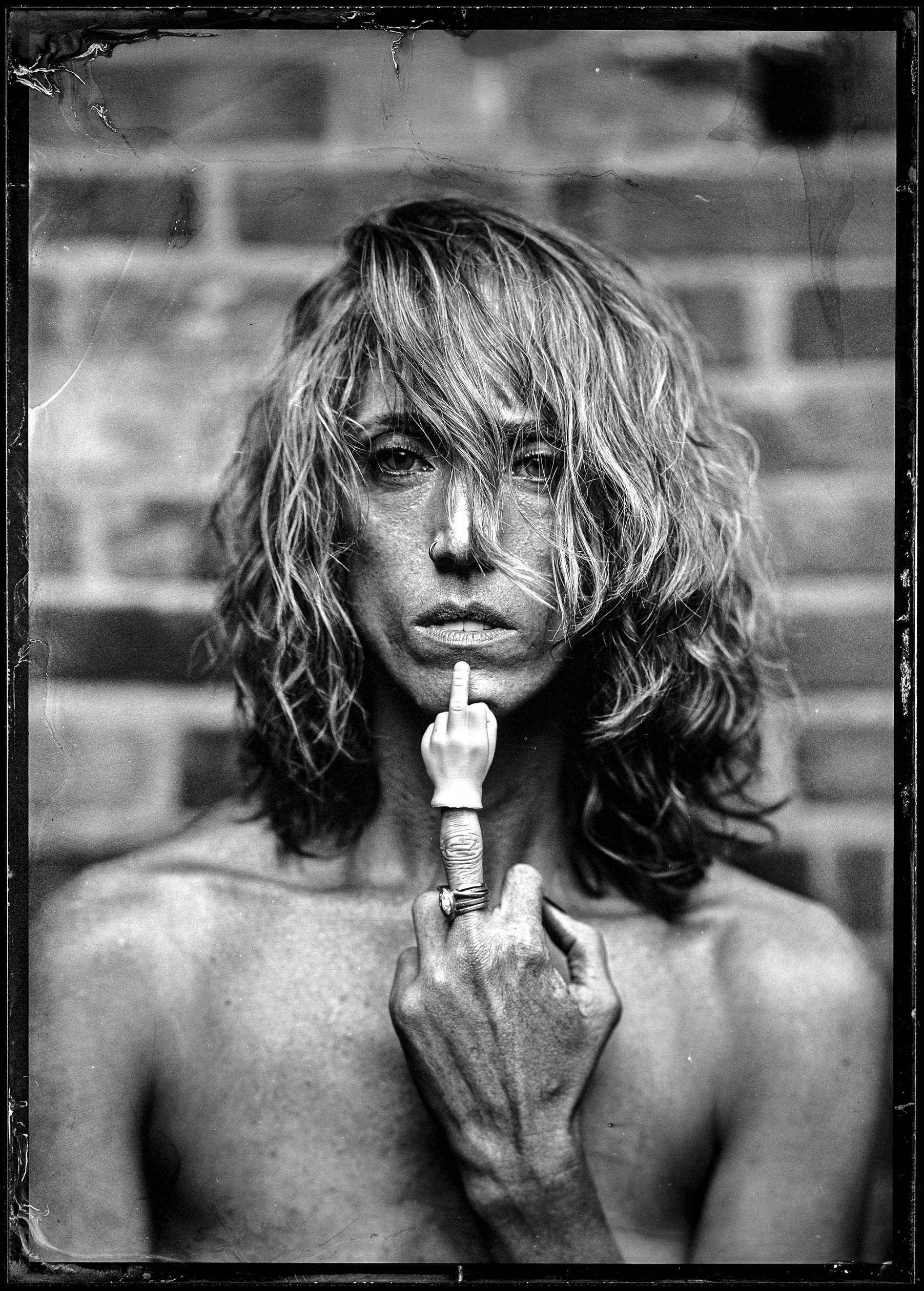 Fine art tintype portrait — bare shoulders, raised middle finger, wet plate collodion
