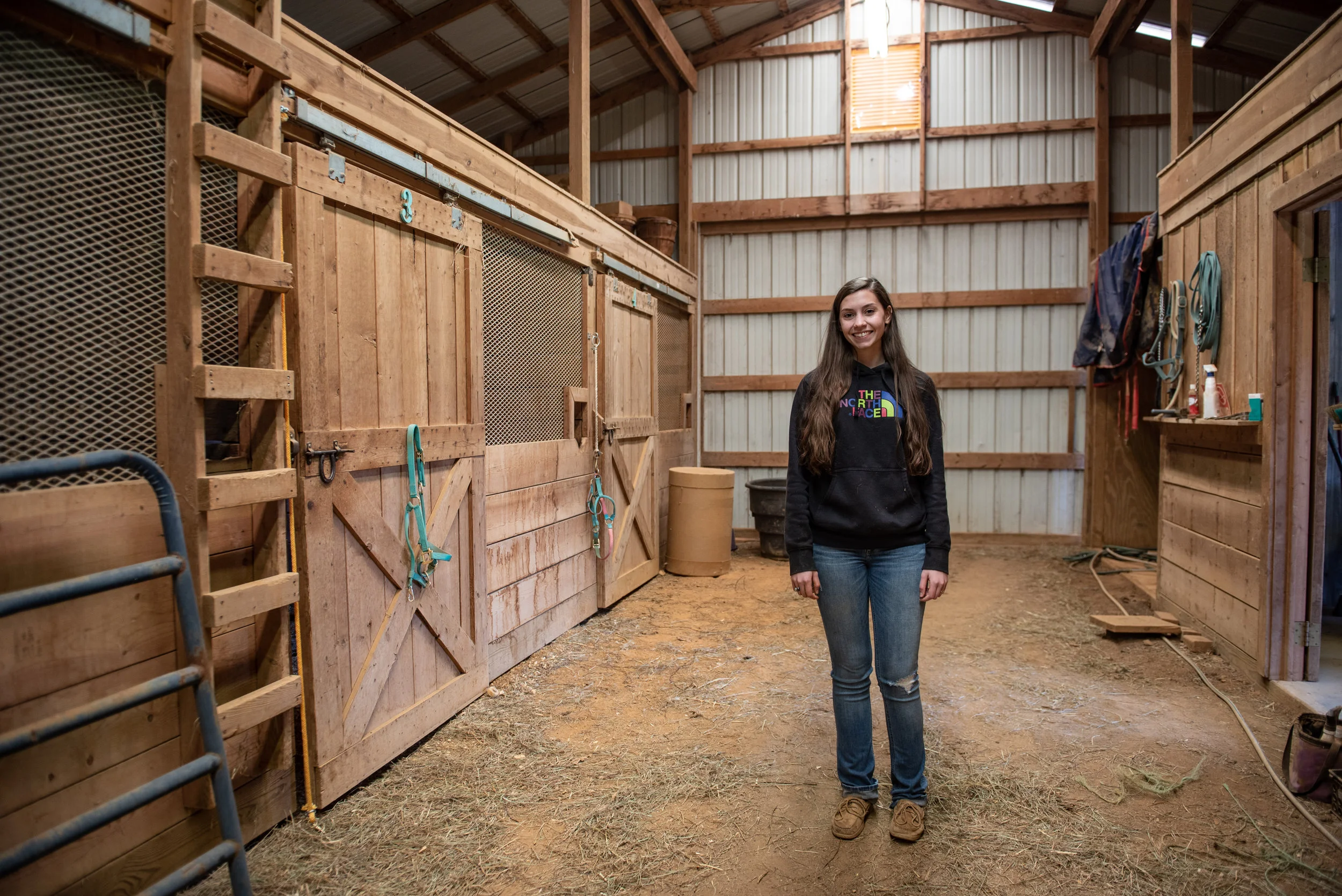 Isabell Grant stands in the barn she rents for her horses, Jetta and Folton.