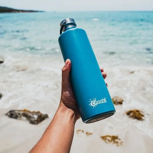 topaz waterbottle in hand on beach.jpeg