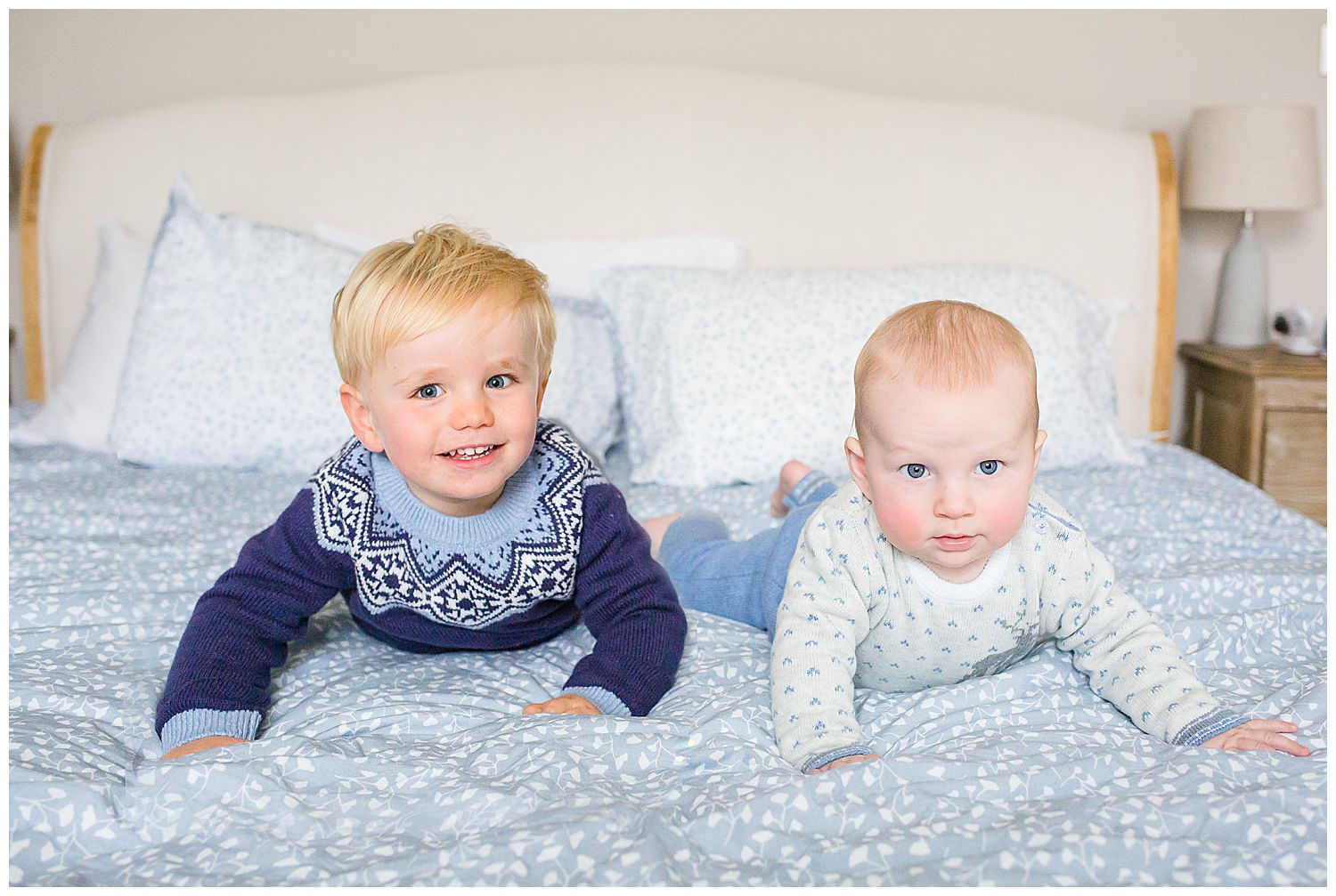 two brothers on tummies on the the bed
