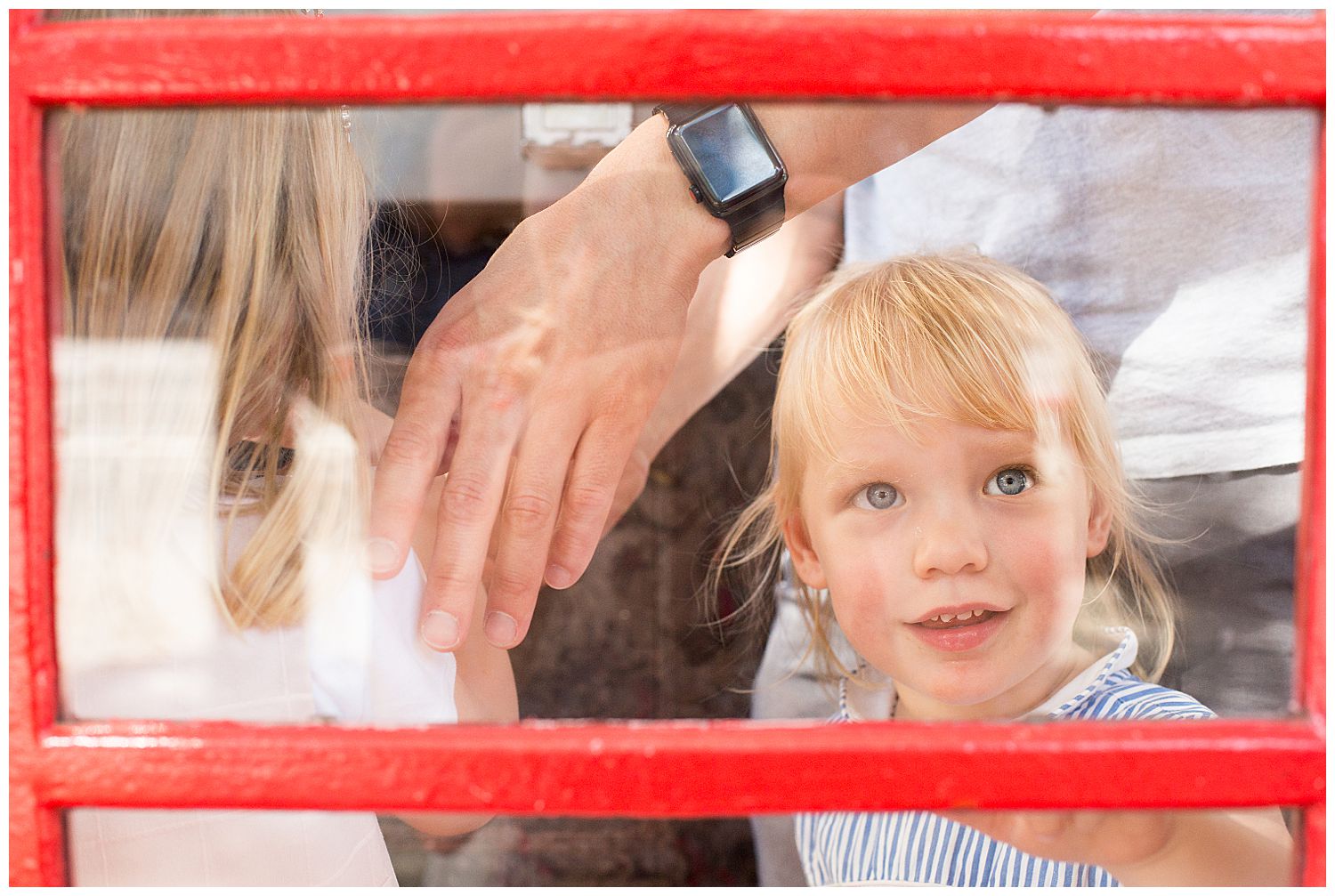 child in red London phonebox