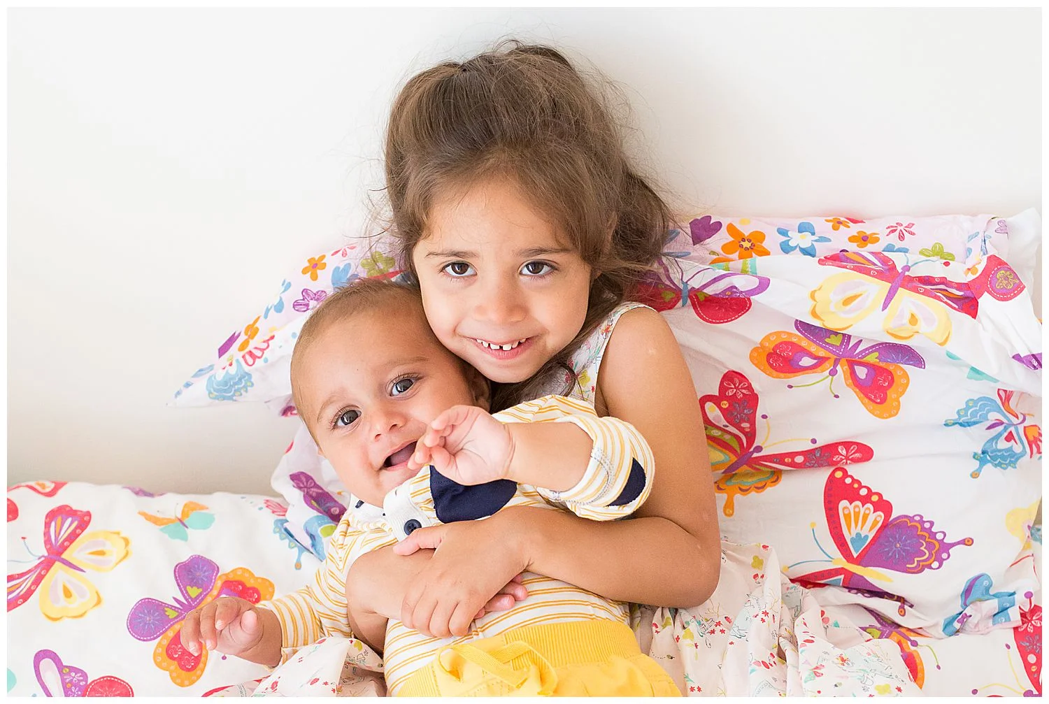 big sister hugging little brother