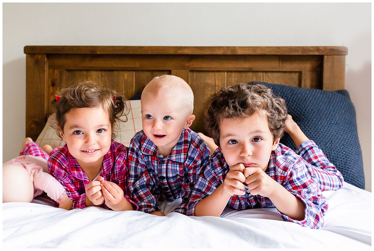 three children lying on bed