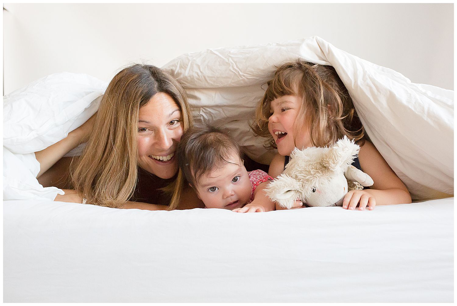 mum hiding under covers with two girls