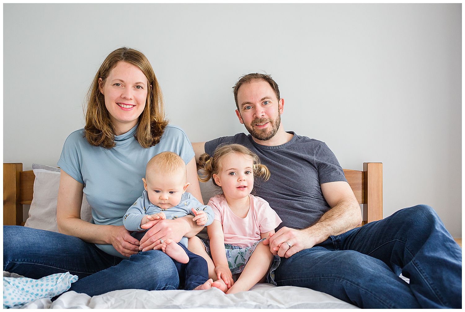 family sitting on bed