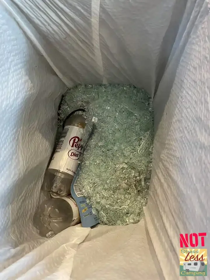 Broken glass in the trash from a shattered shower door.webp