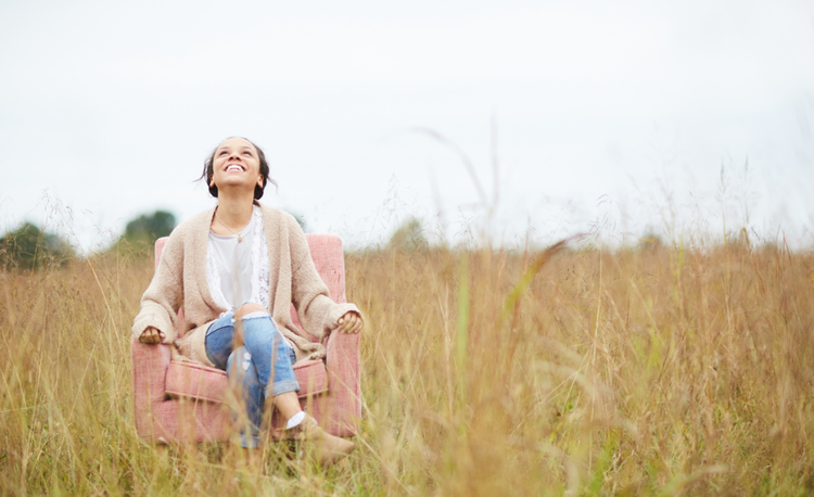 image of a woman sitting in a chair outside looking up