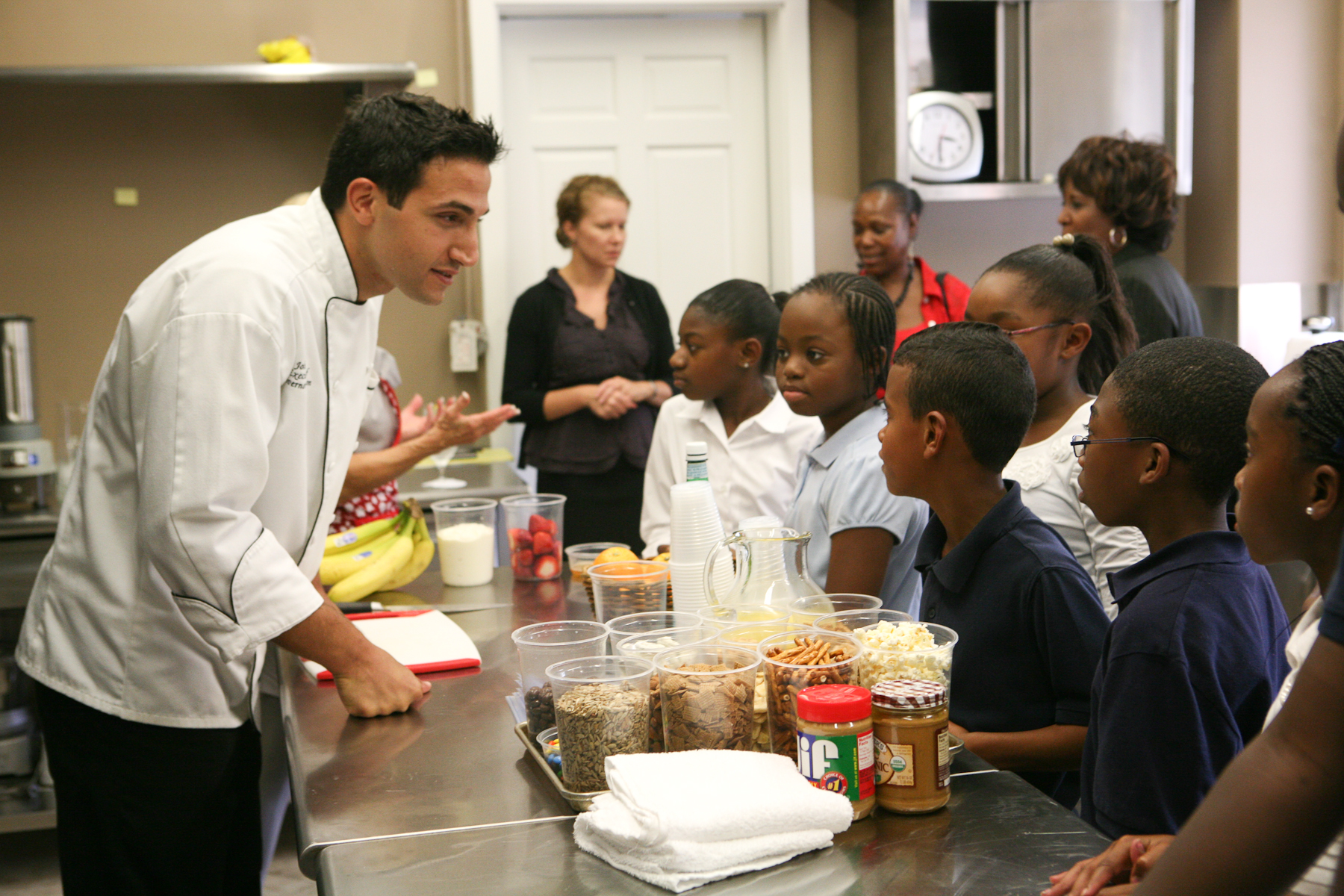 Chef Minas, at the Governor's Mansion, educating local students and community members demonstrating a simple healthy snack substitute.
