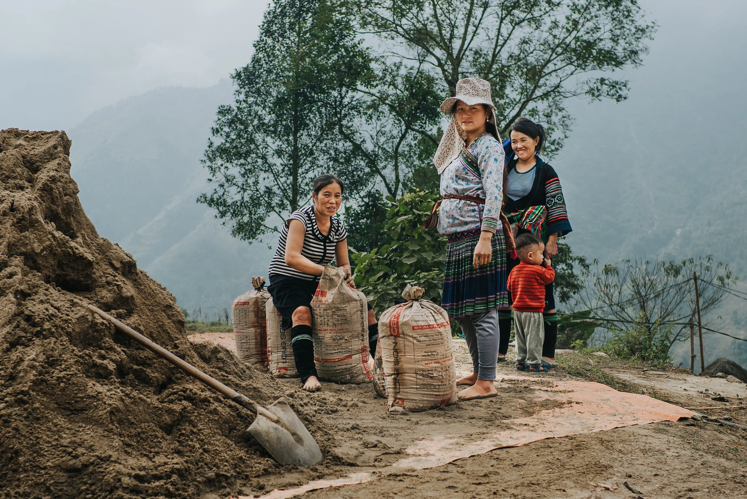 Women carrying sand bags up the mountain to build homes.