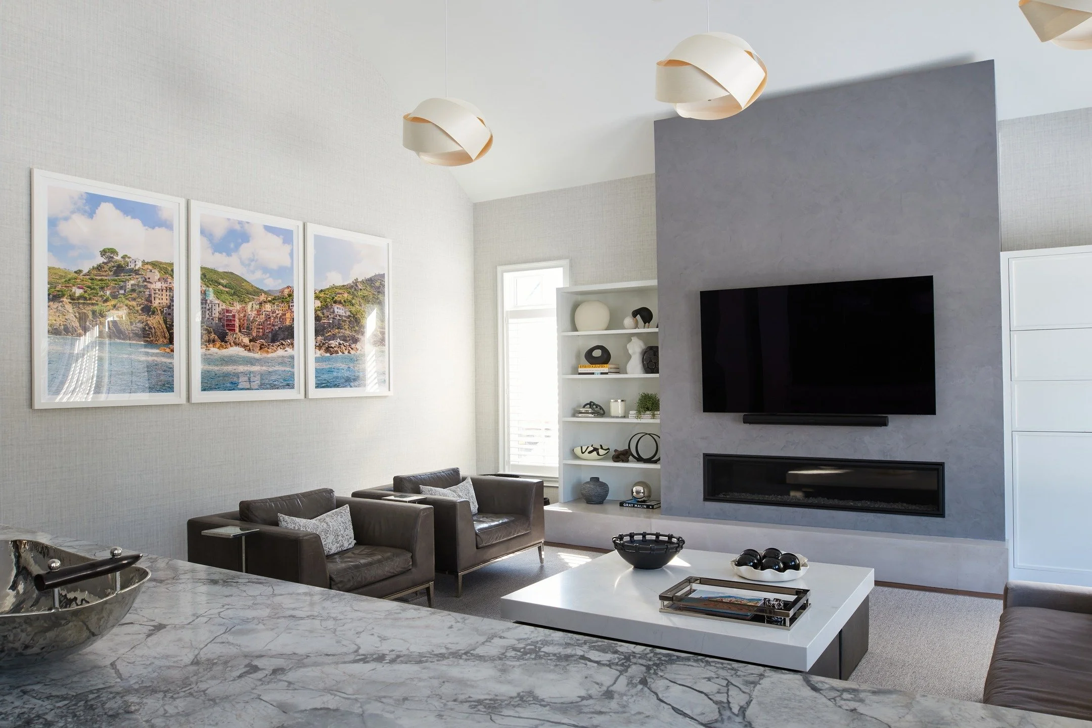 This two-story family room was screaming for drama from the lights. Love these wood pendants from @1stdibs
Shelf styling can be overwhelming. @cb2 made this job easy

Architect and construction: @theodellgrp 
Photography: @joebuzzeophoto
