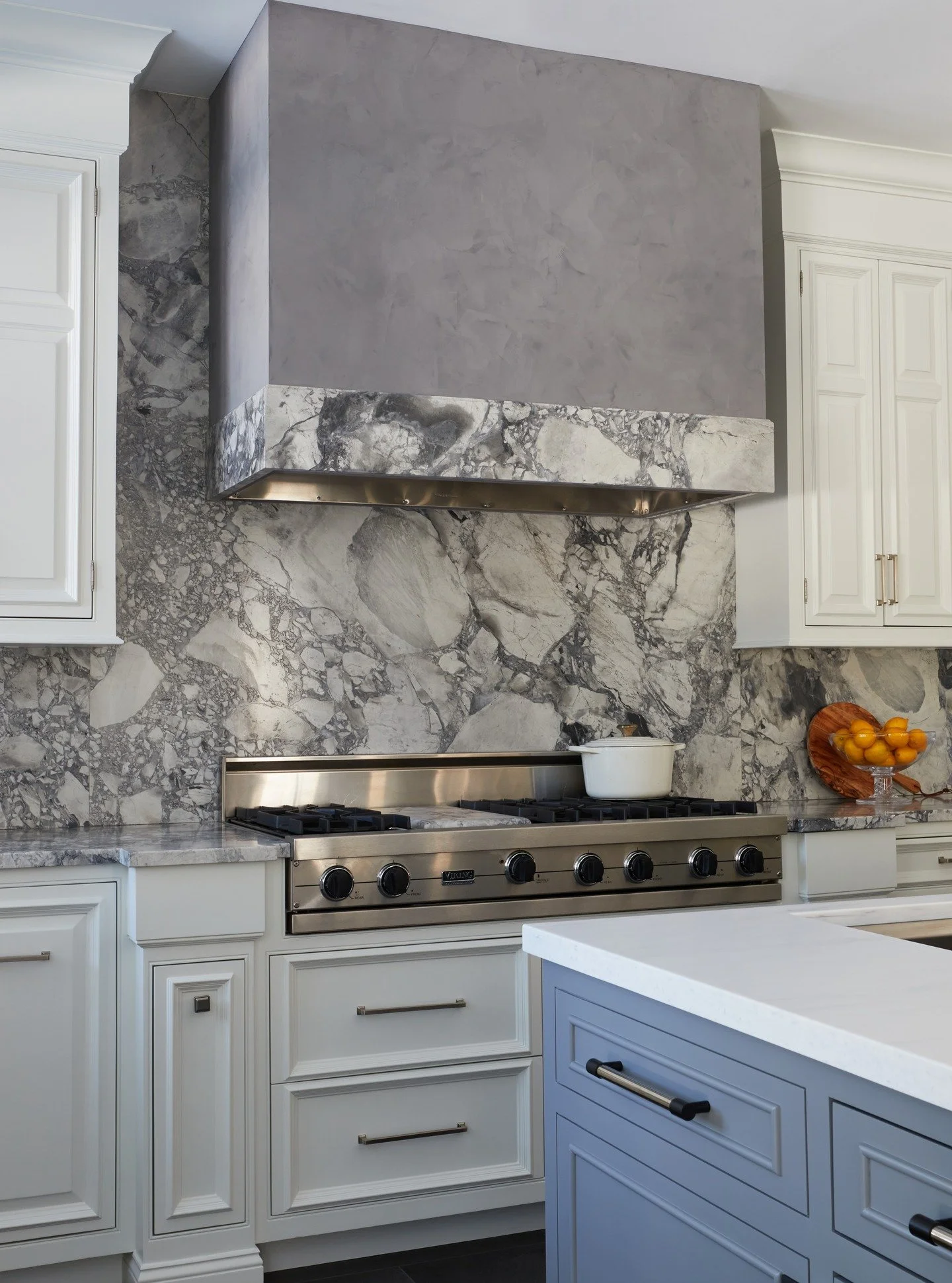 A black, white, and grey room can look flat and a little boring. The texture of the stone and the Roman clay hood make sure this kitchen brings the drama.

Photography: @joebuzzeophoto 
Tile and Counters: @karenberkemeyerhome