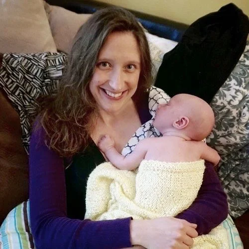 Sarah Adelmann, holding newborn baby