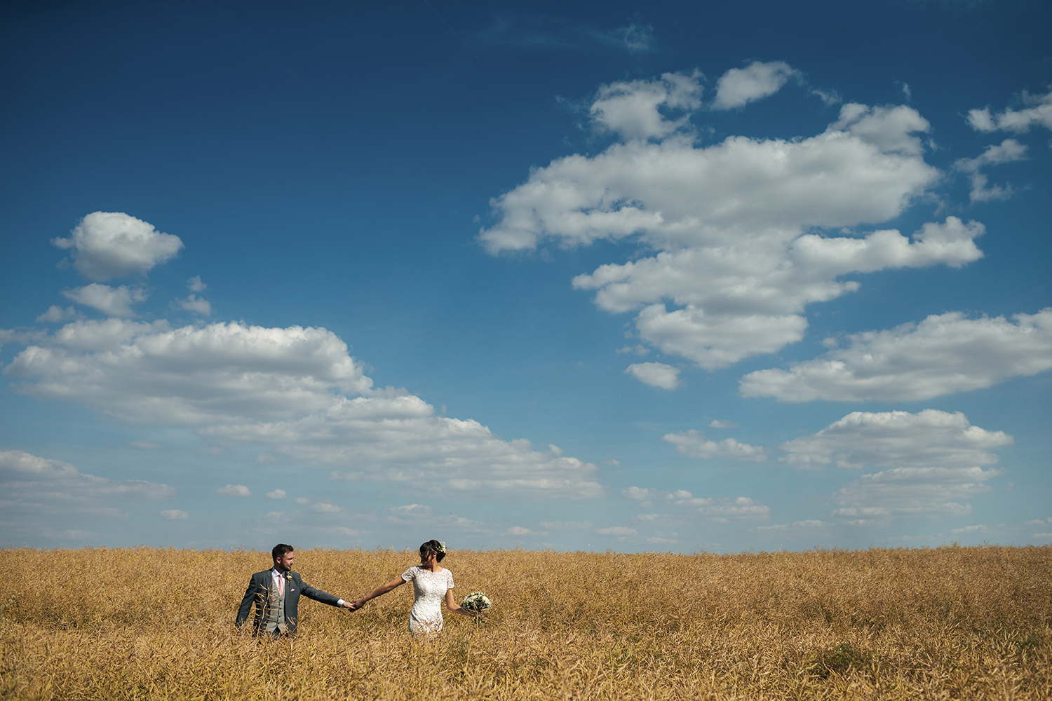 Bride and Groom walking through field