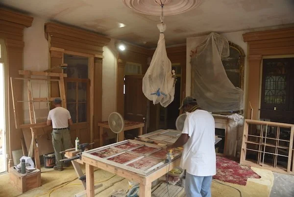  Two workers restore window sashes. 