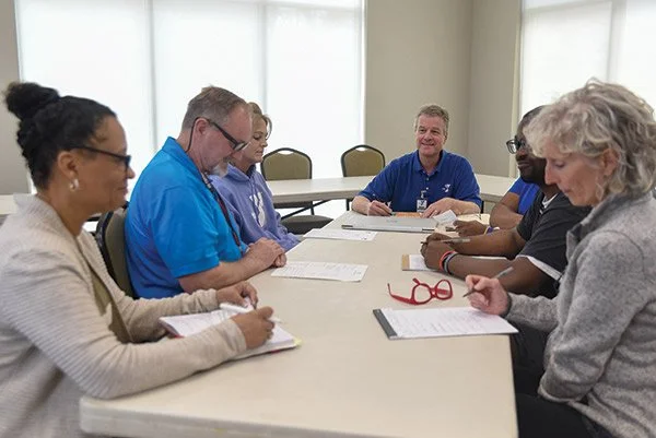  Columbus Y Director Jimmy Woodruff, center, and staff members plan the organization’s centennial celebration.  
