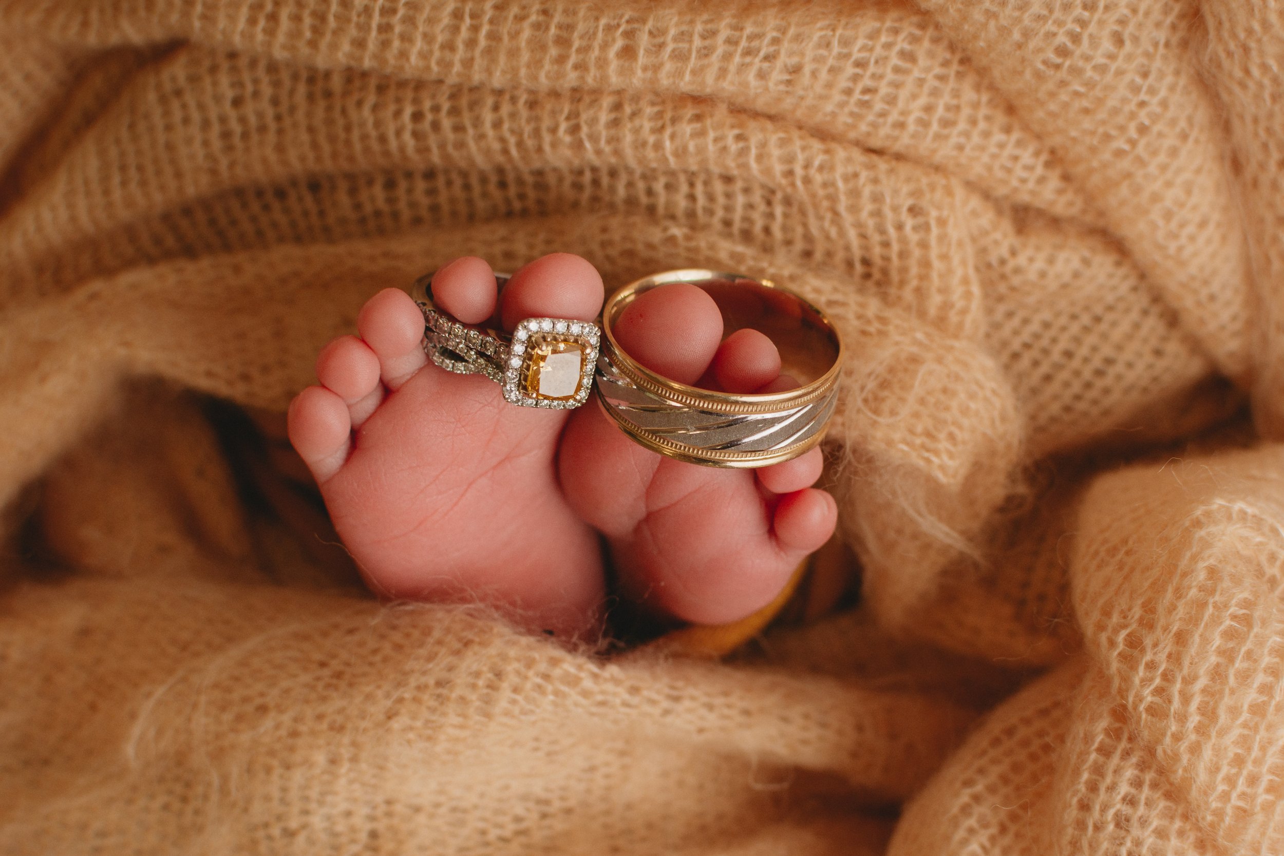 newborn baby feet with wedding rings