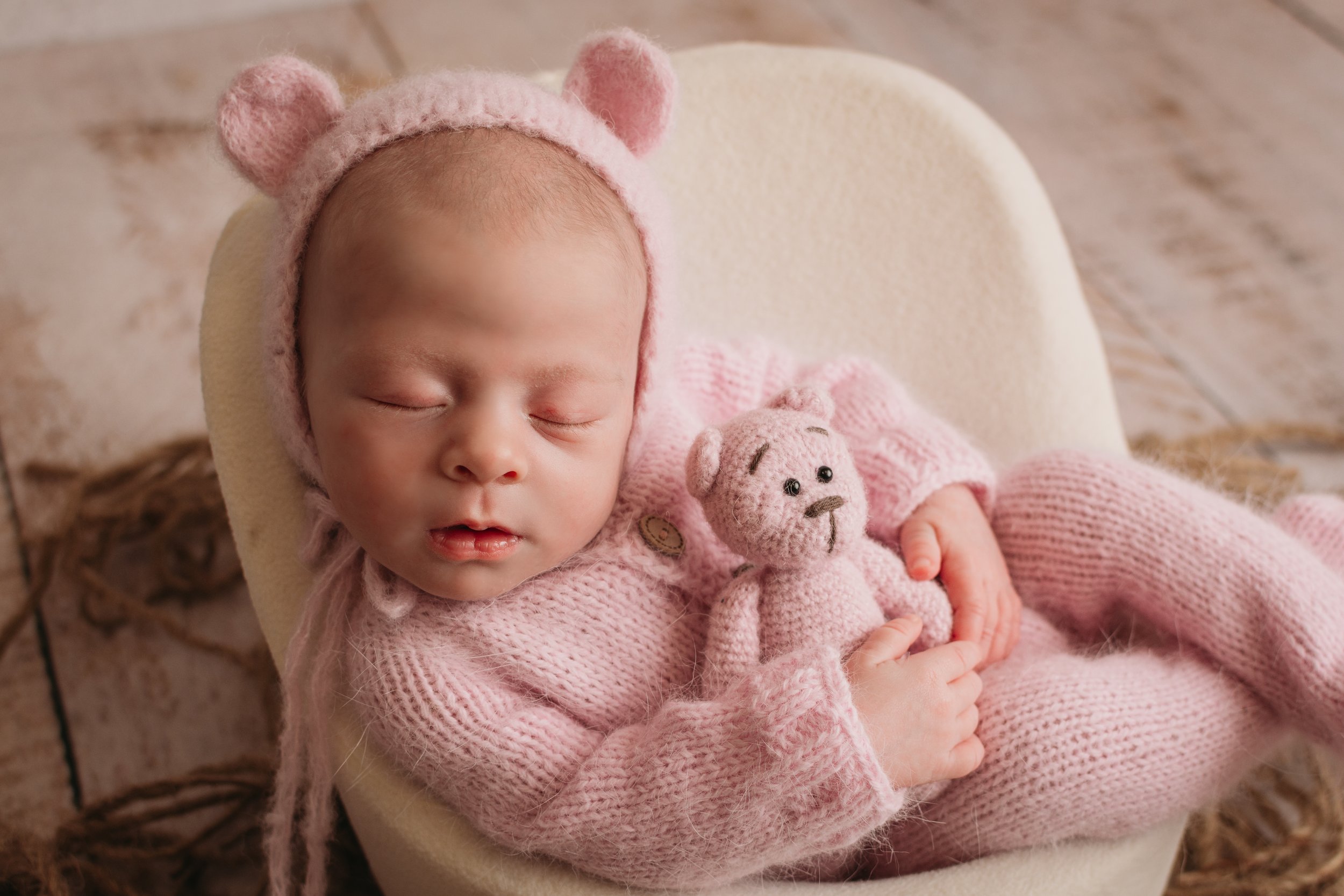 Newborn baby girl in pink bear bonnet